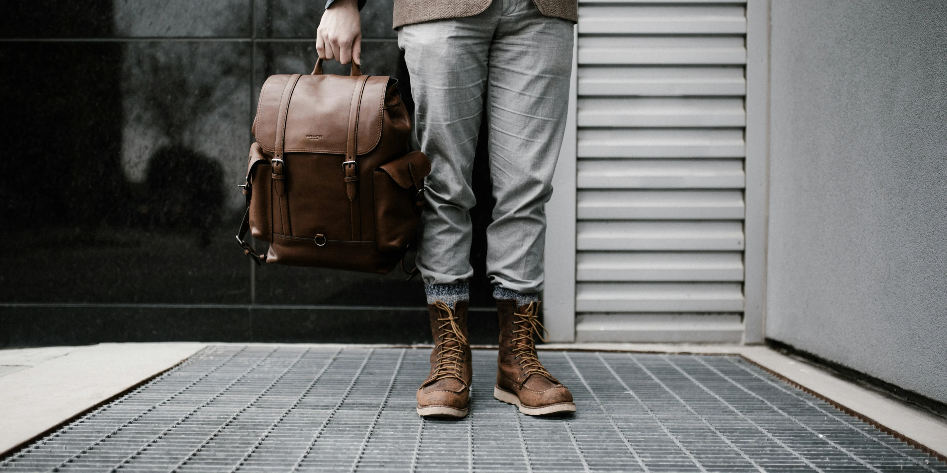 person holding brown leather bag