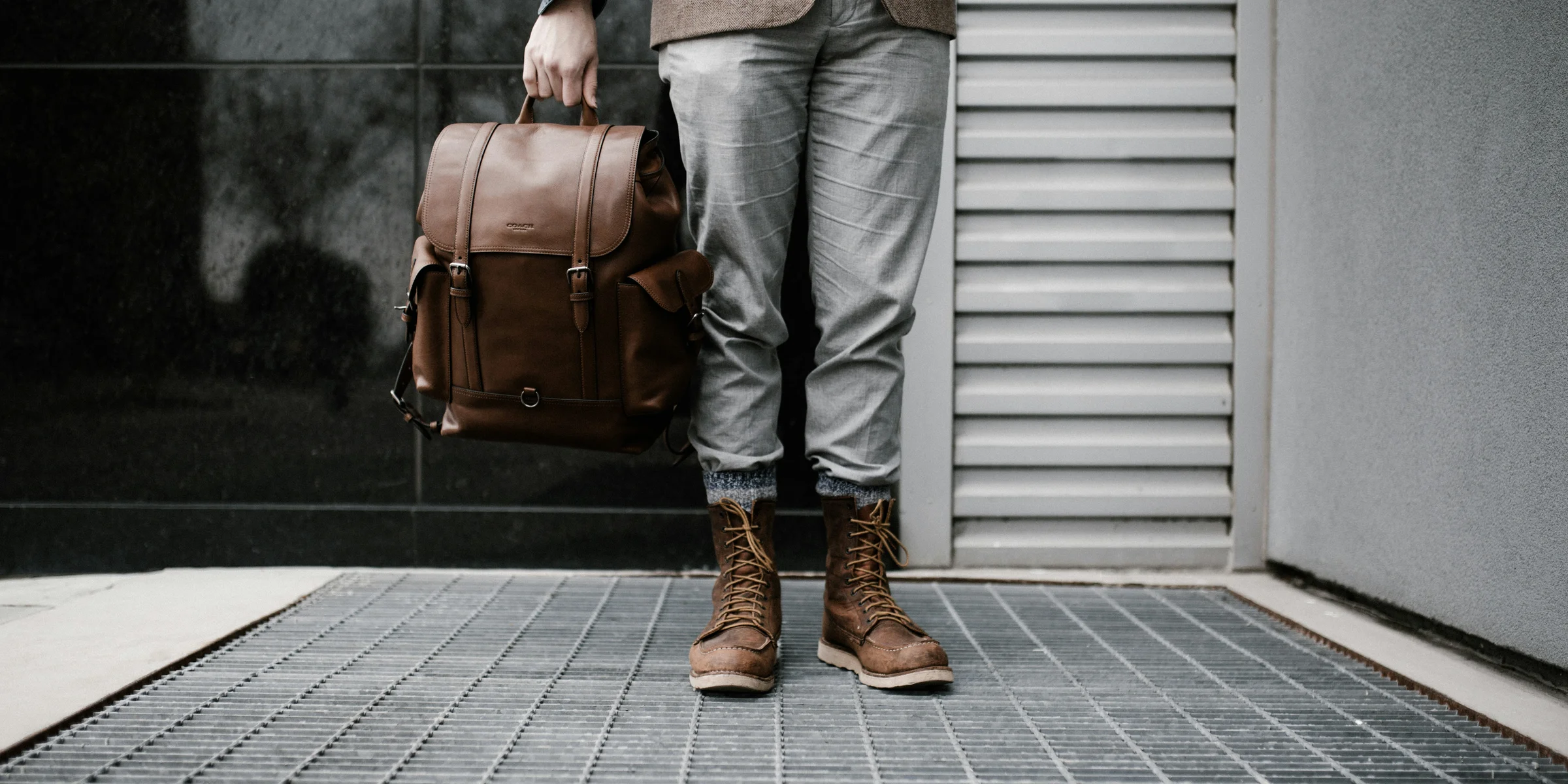 person holding brown leather bag