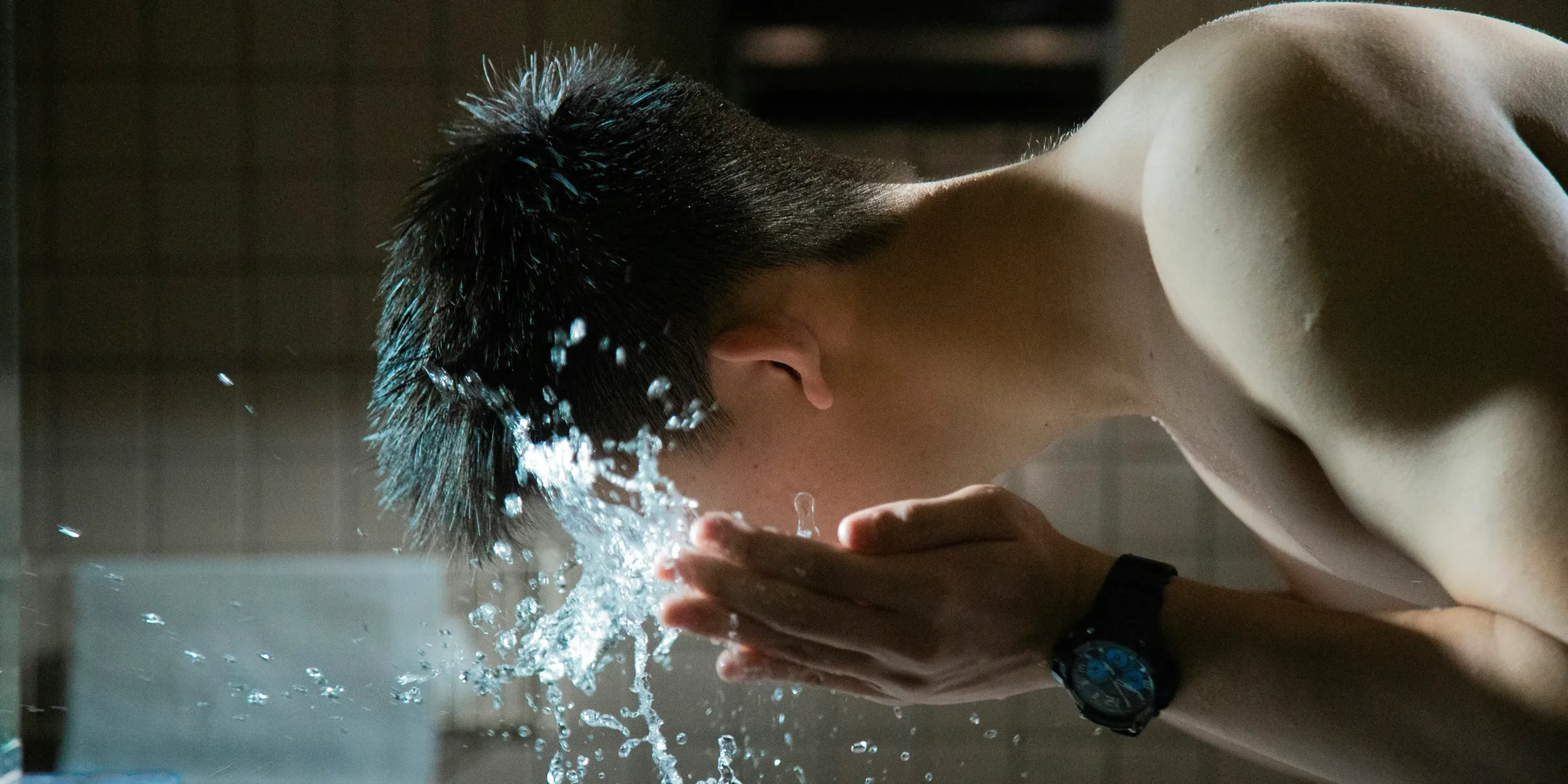 person washing face with water