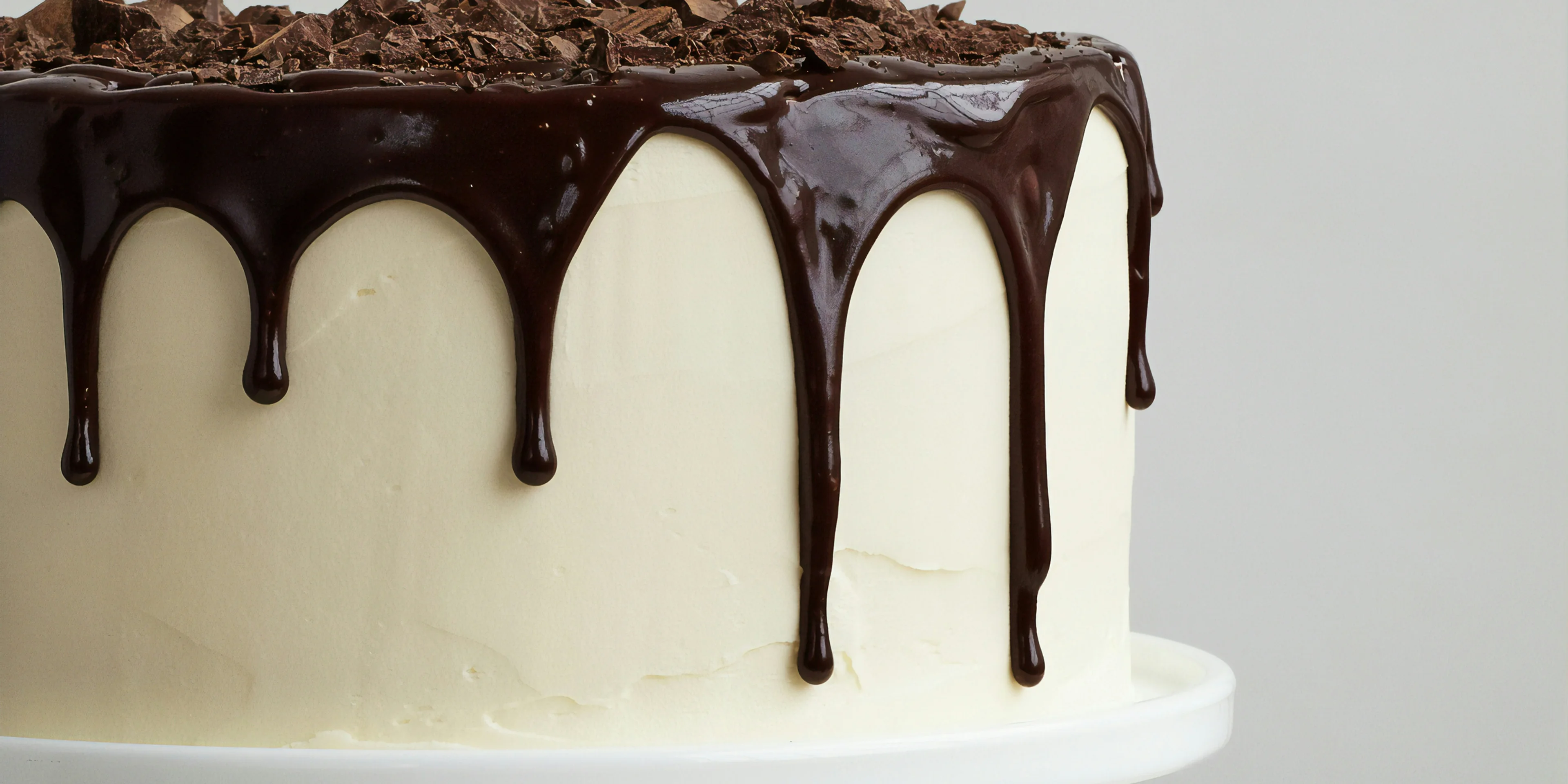 white cake with chocolate syrup on white ceramic plate.