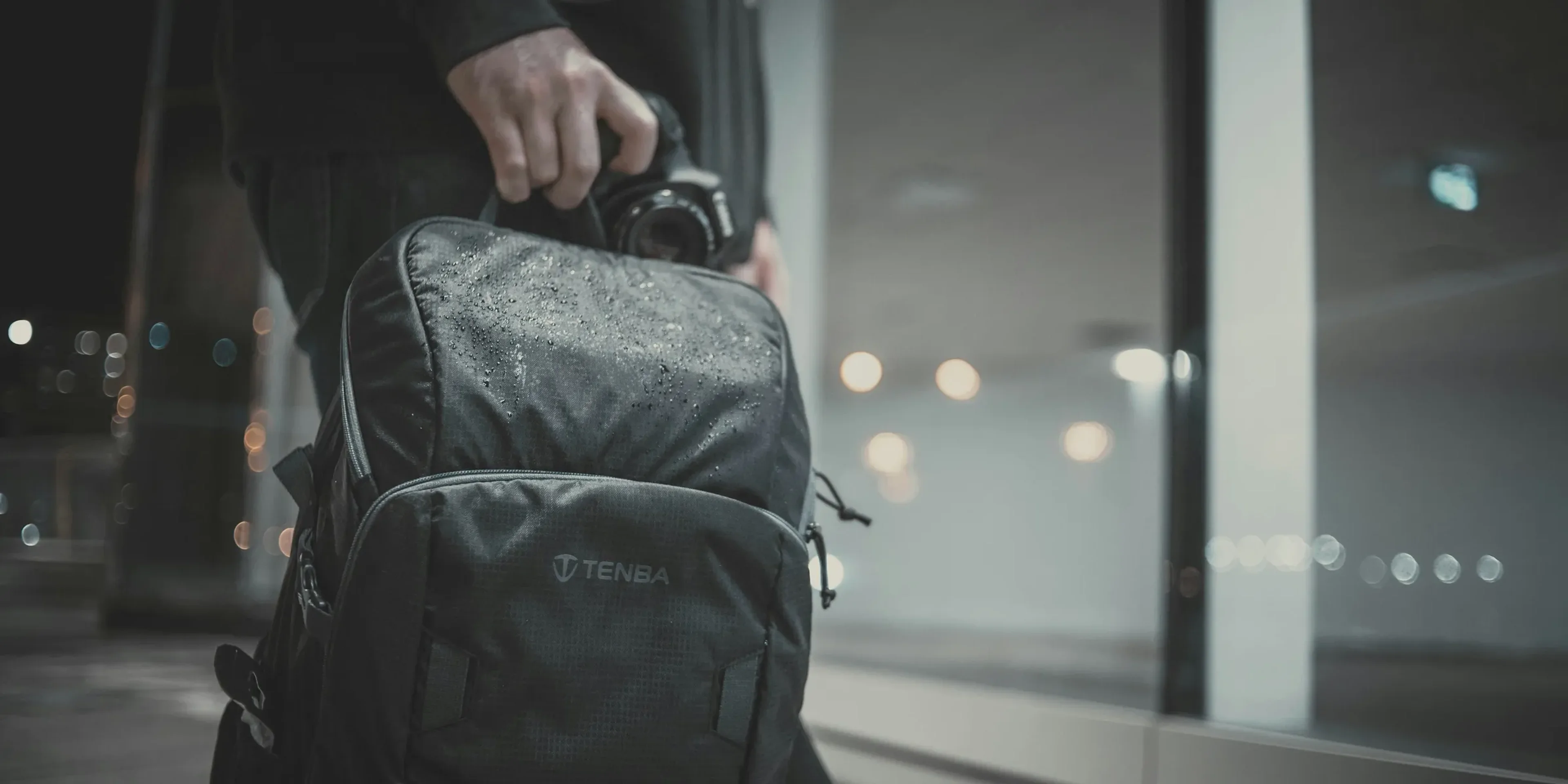 a man carrying a black backpack and a camera