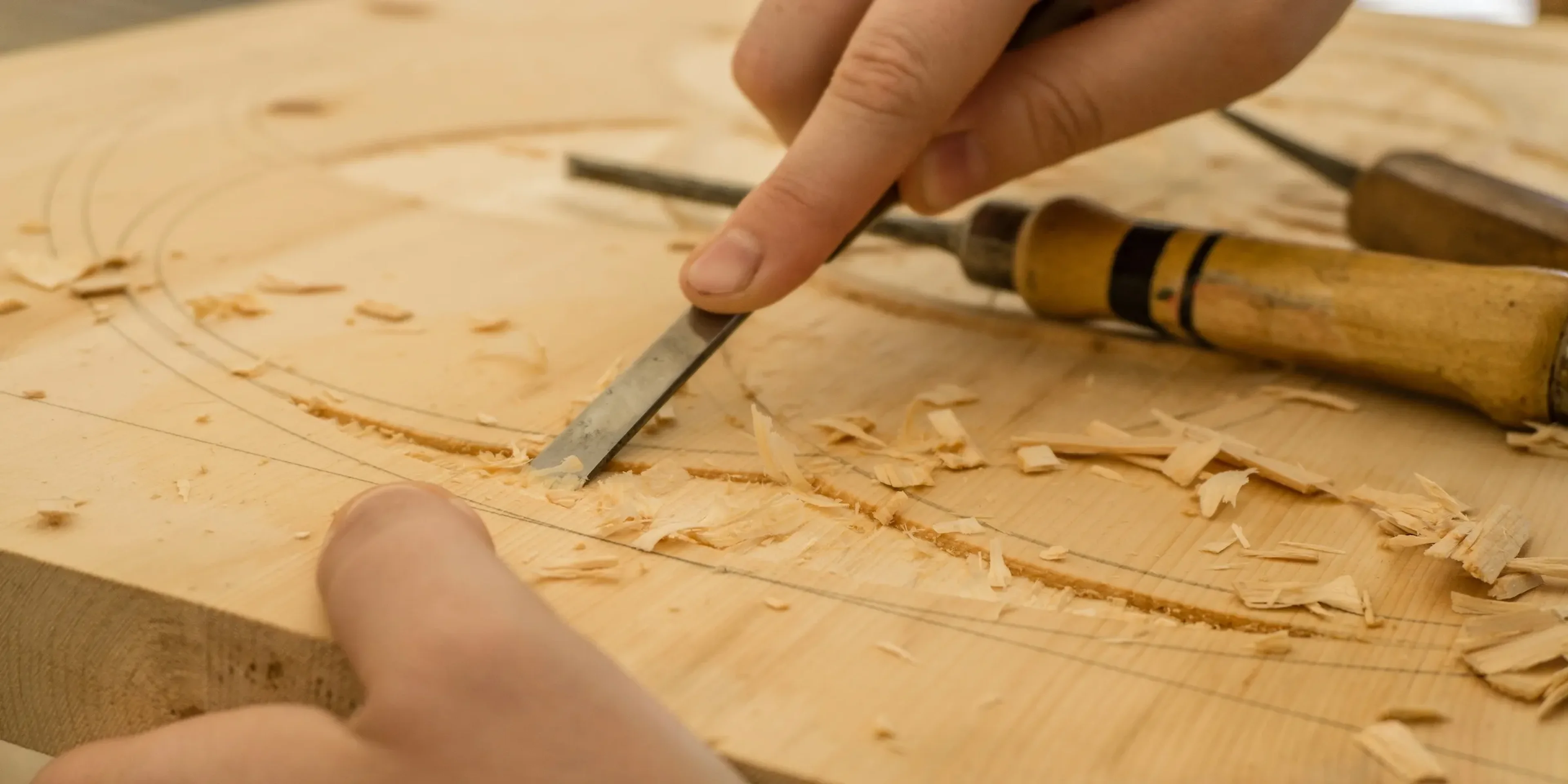 two hands carving wood