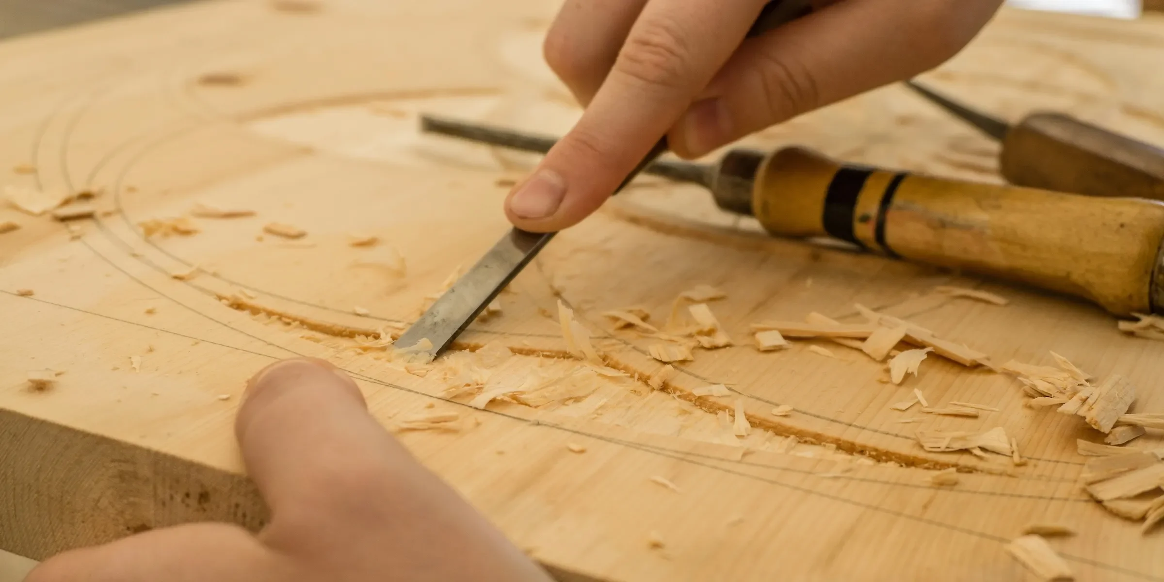 two hands carving wood