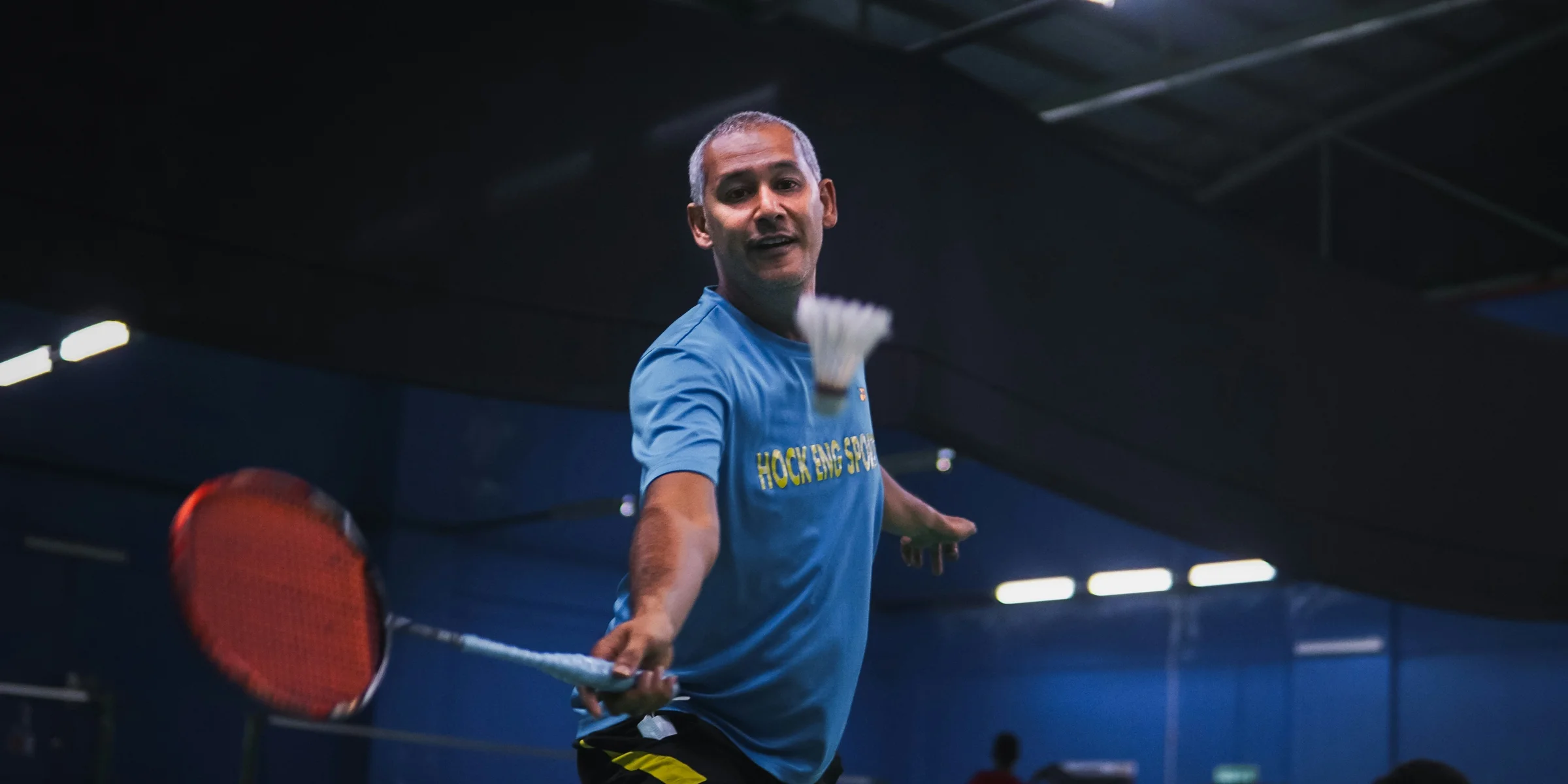 man in blue crew neck t-shirt and black shorts holding red basketball