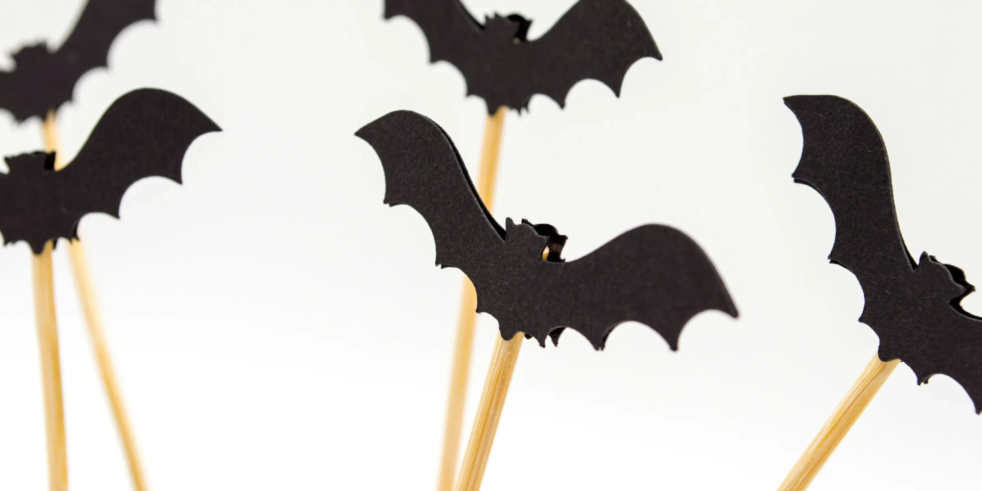 five black toy bats with sticks