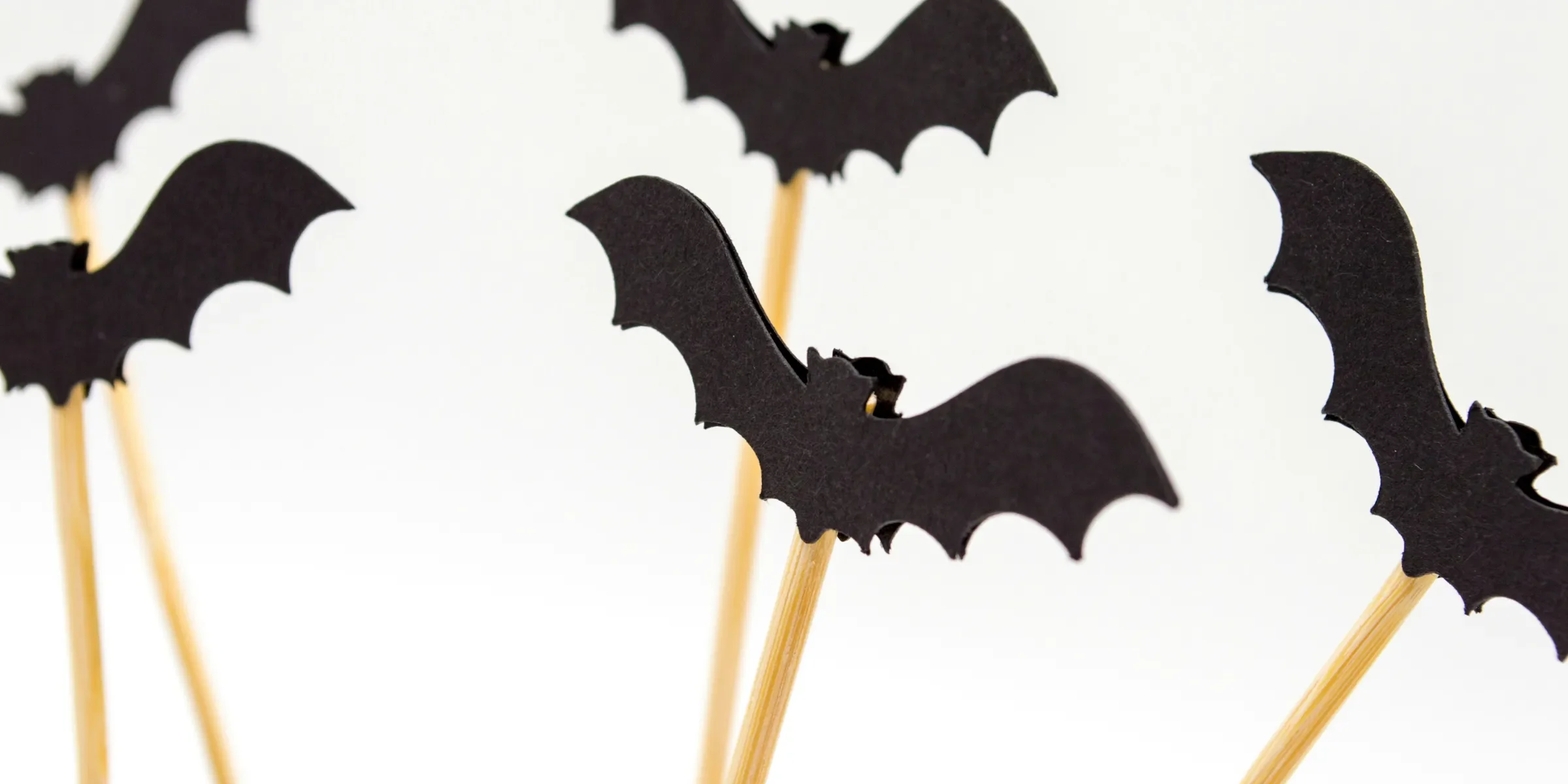 five black toy bats with sticks