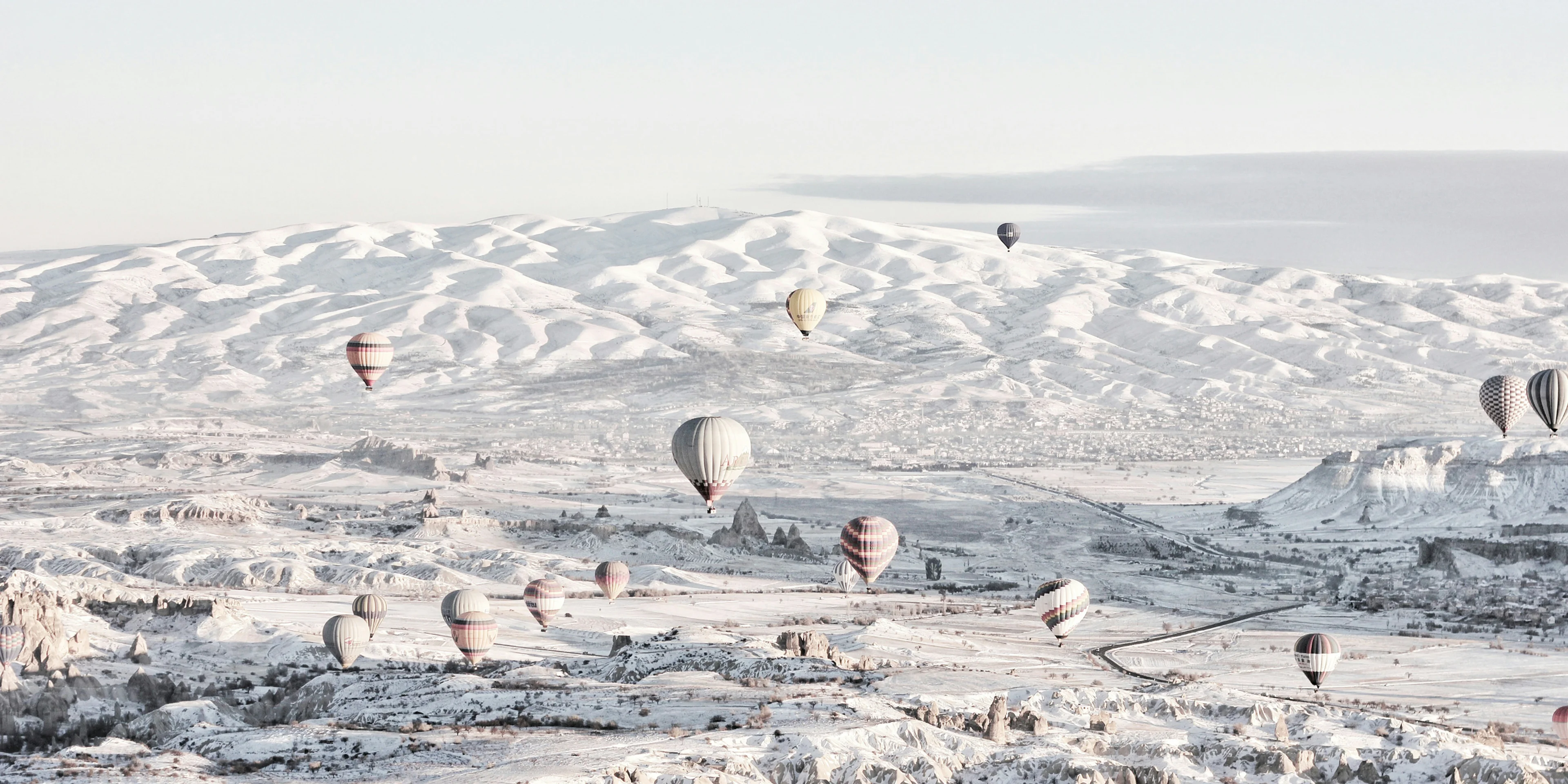 assorted-color air balloons below snowland at daytime