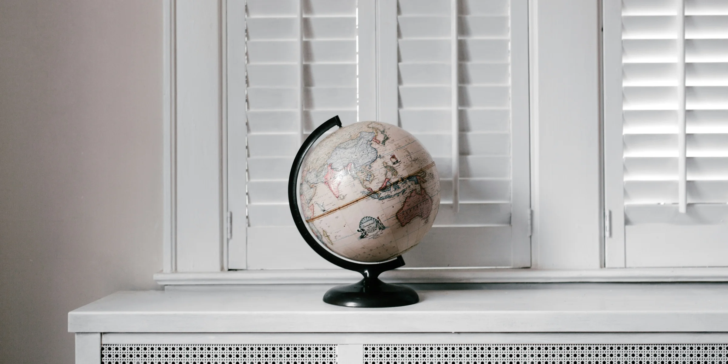 beige desk globe on white desk.
