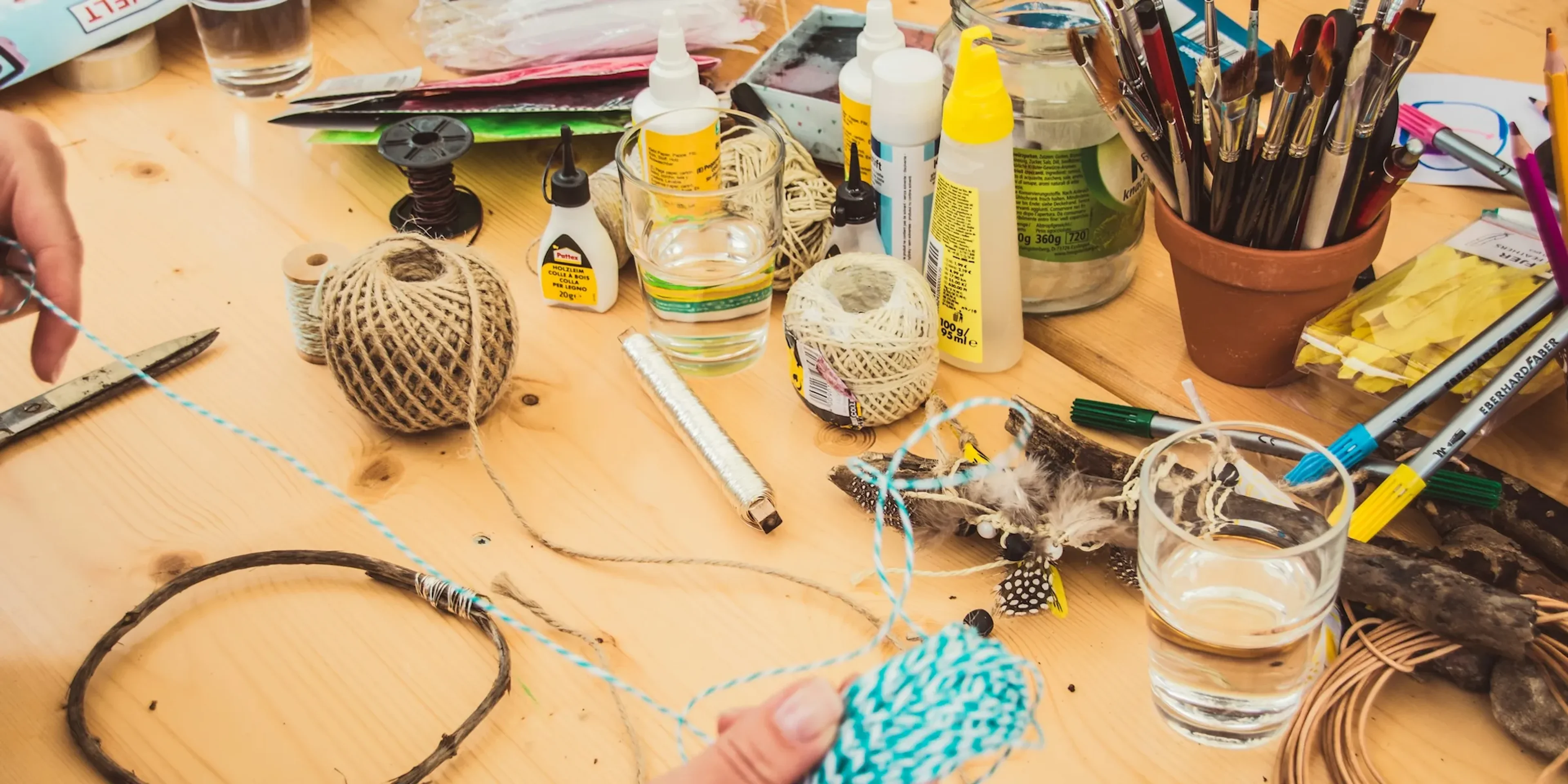 A person at a table with string and other diy materials