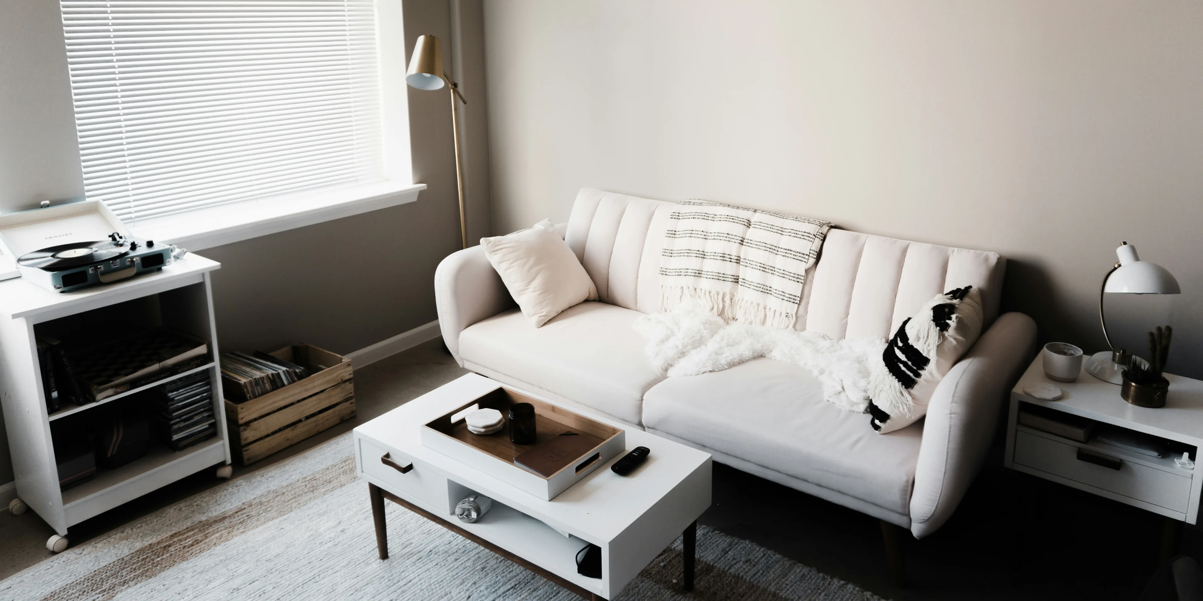 white couch in front of white wooden table.