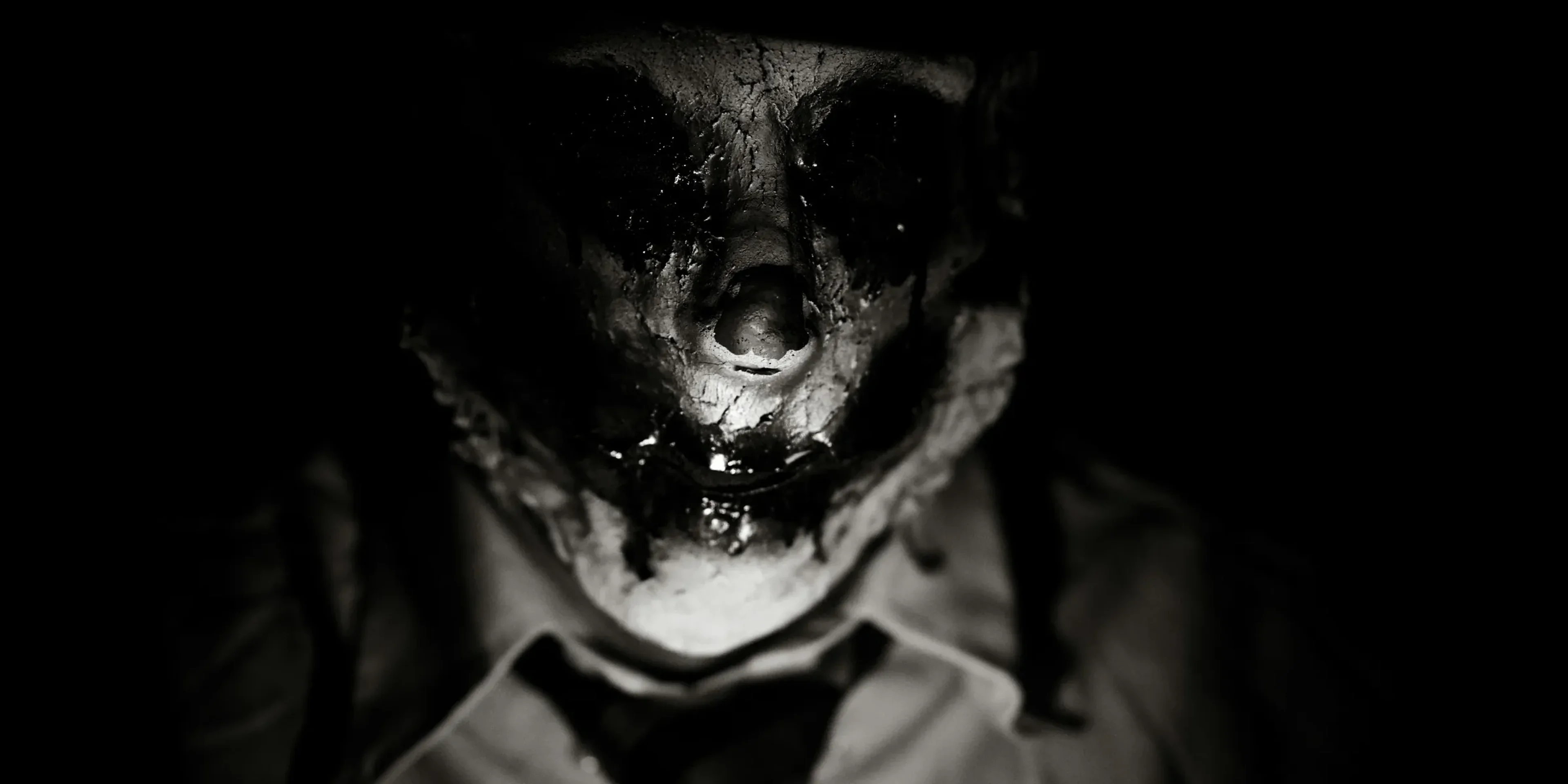 a man wearing a creepy mask and a tie