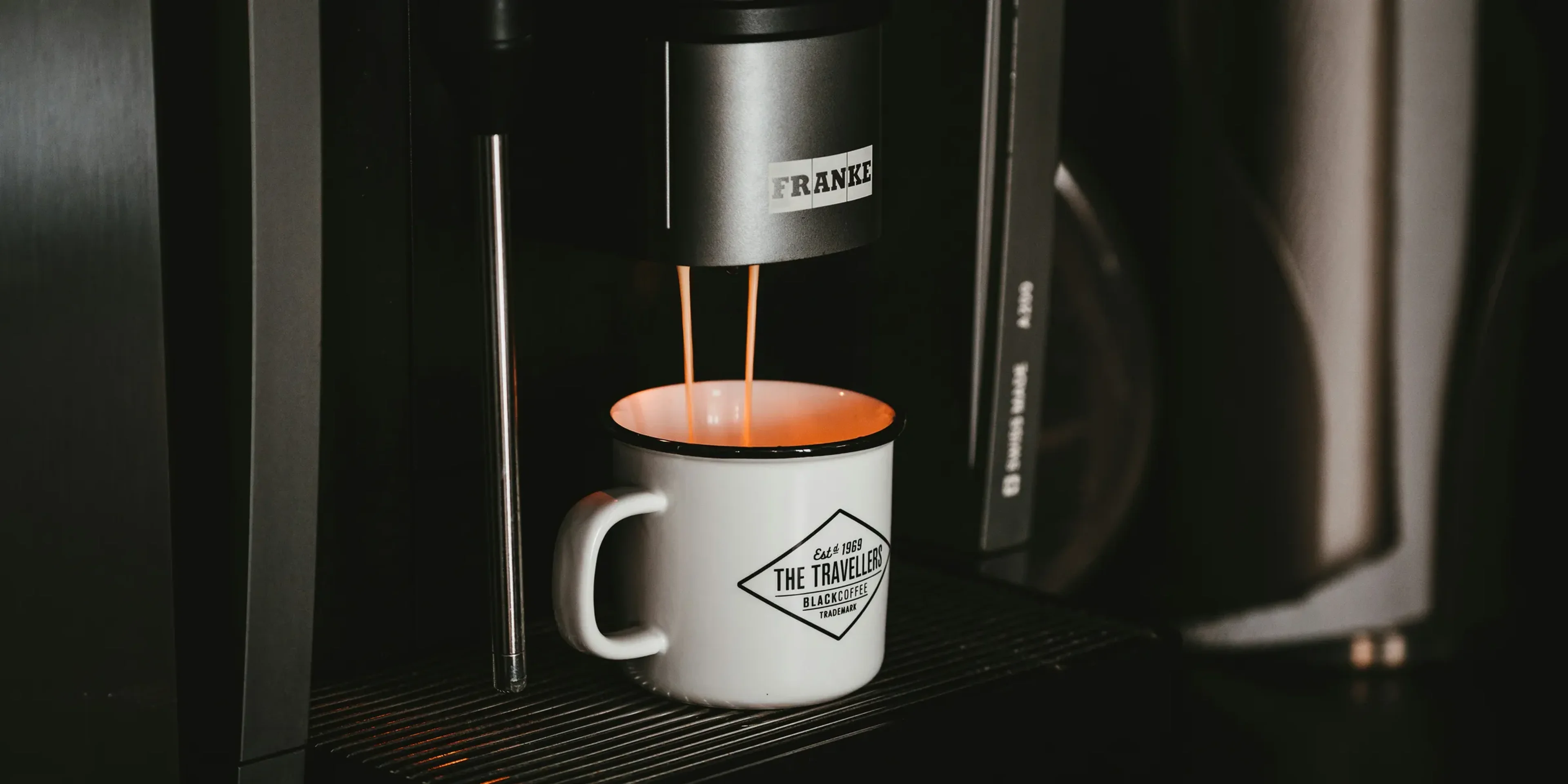white ceramic mug on black and silver coffee maker