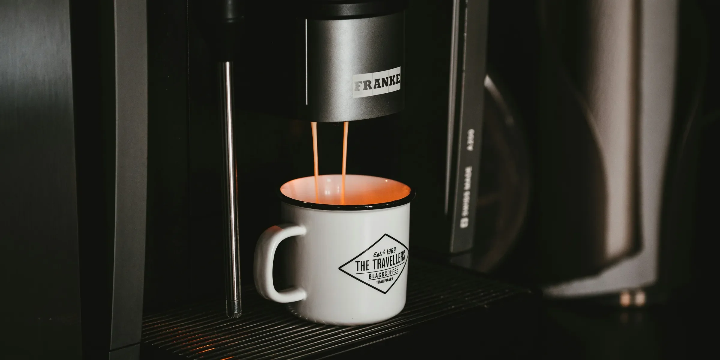 white ceramic mug on black and silver coffee maker