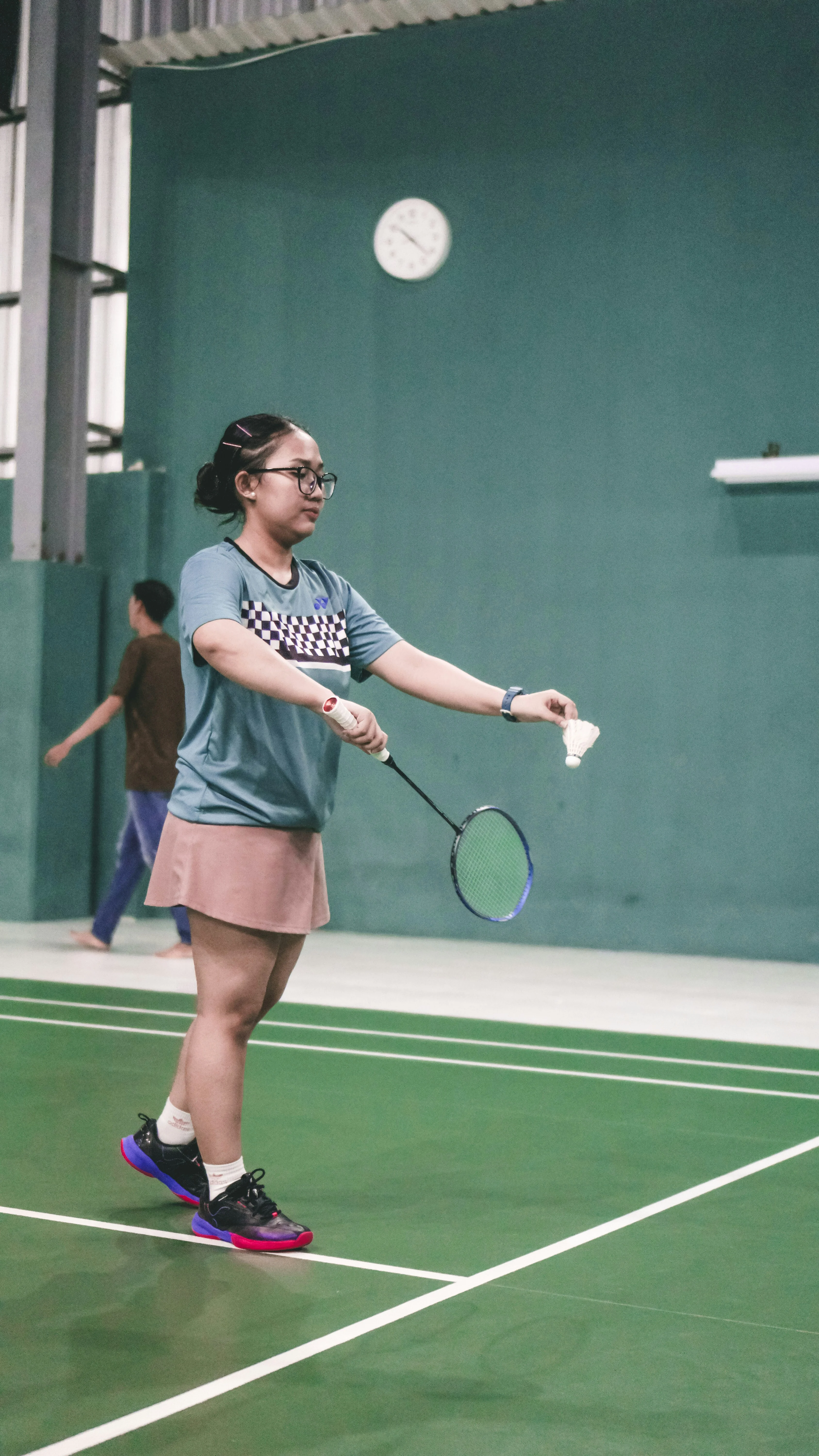 girl playing badminton indoors