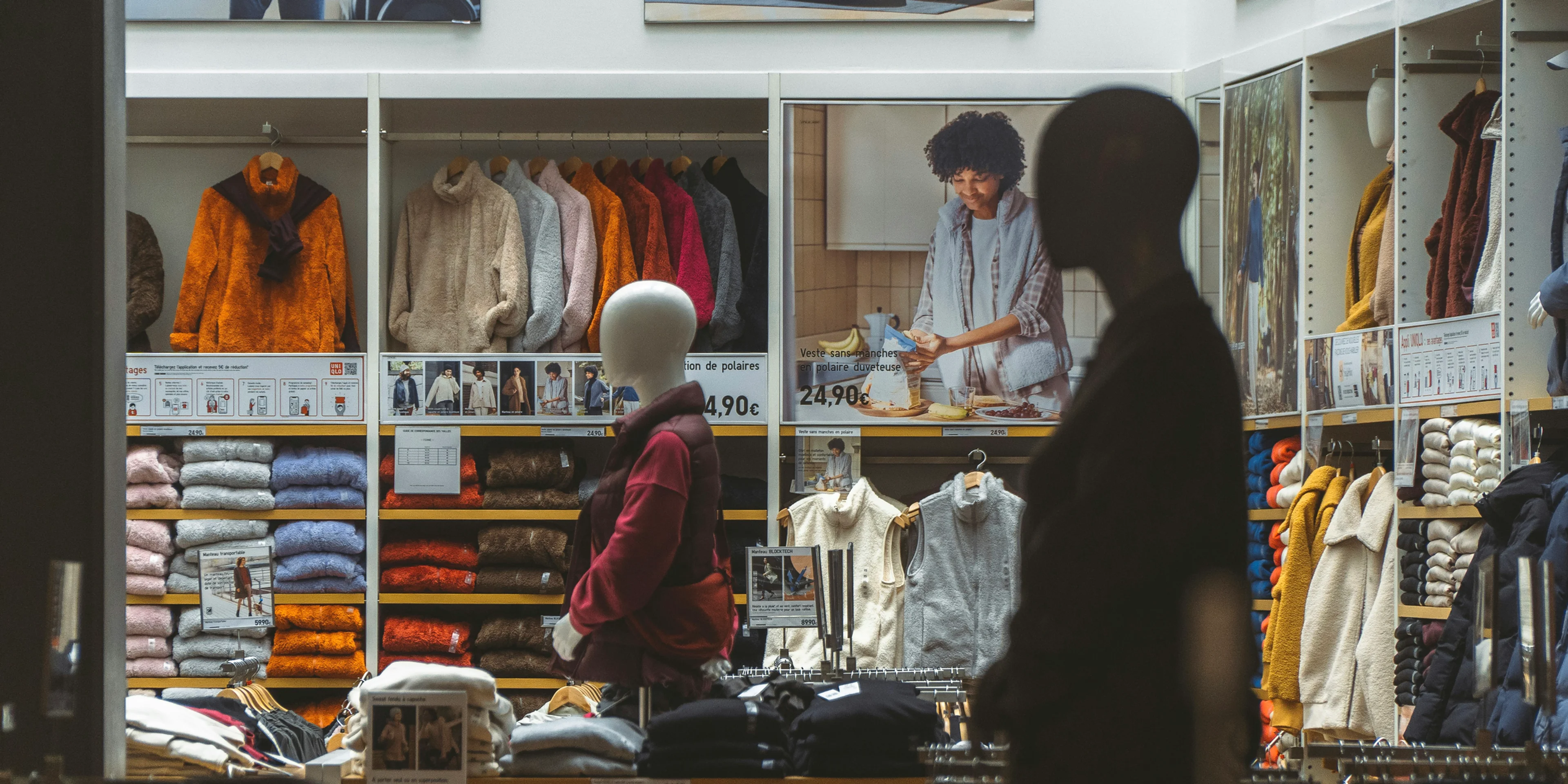 a man standing in front of a store filled with clothing