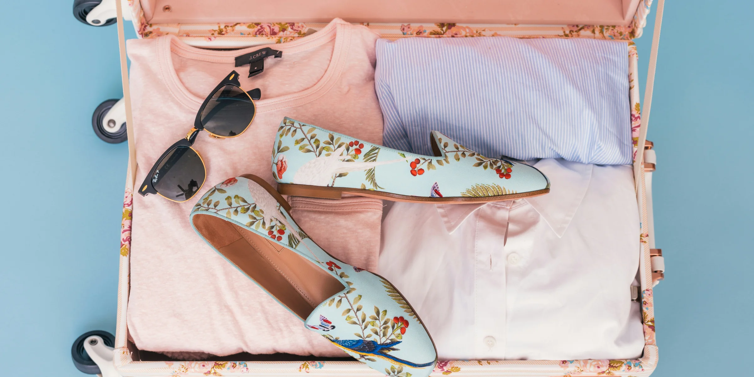 clothing items and pair of shoes in luggage.