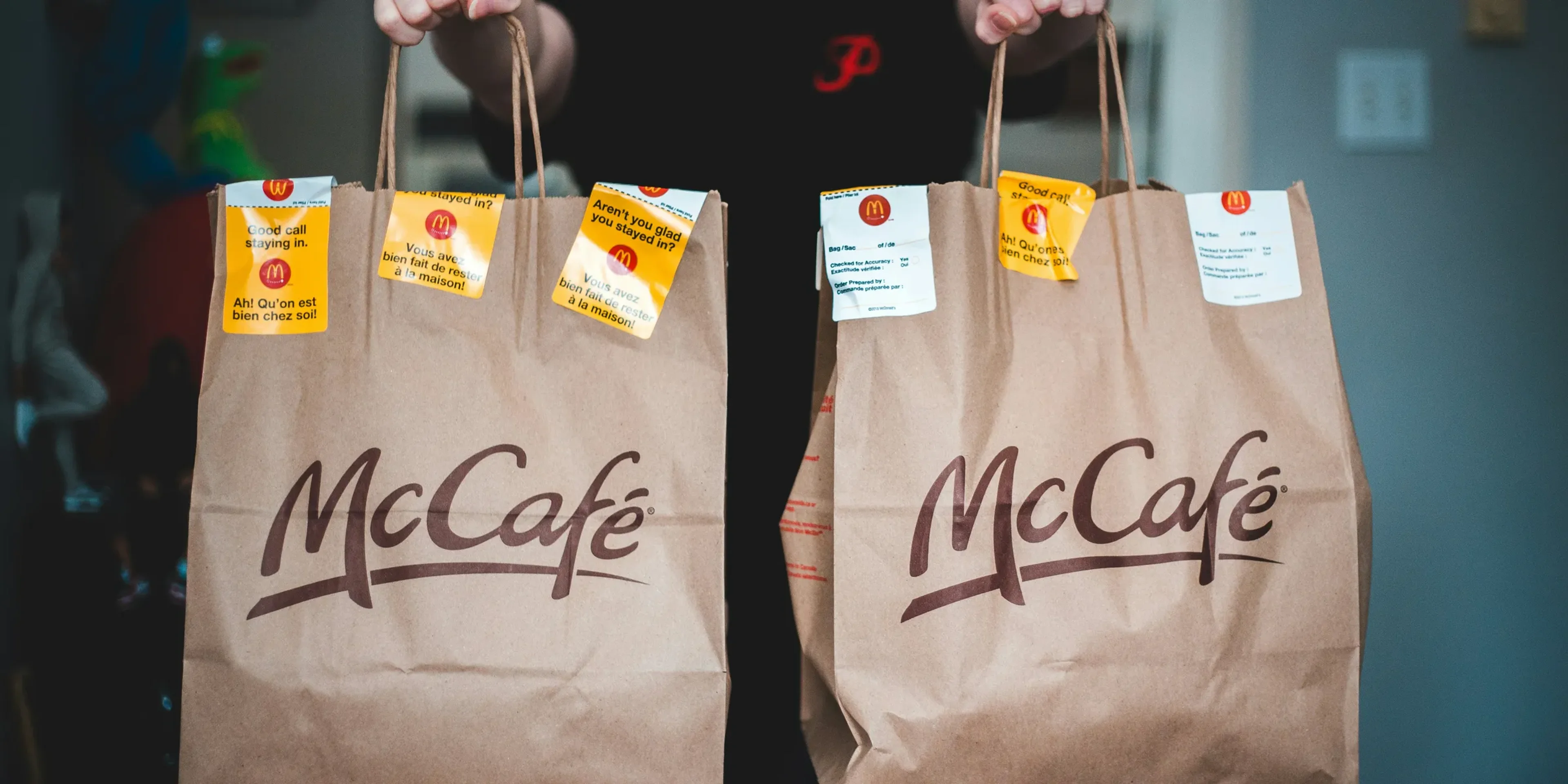 person holding white and brown tote bags