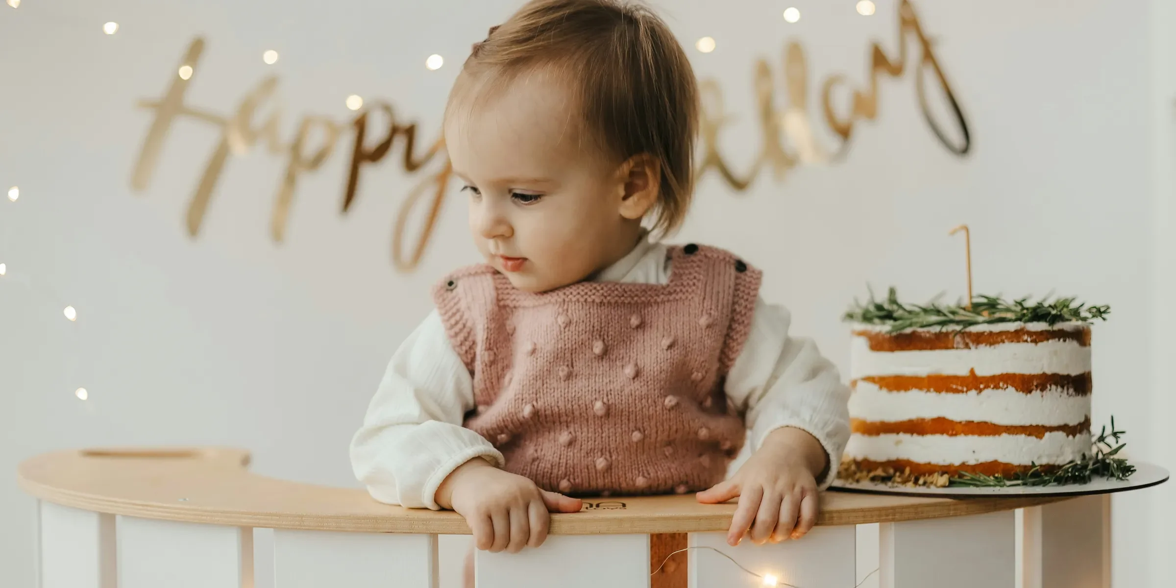a baby sitting at a table with a cake