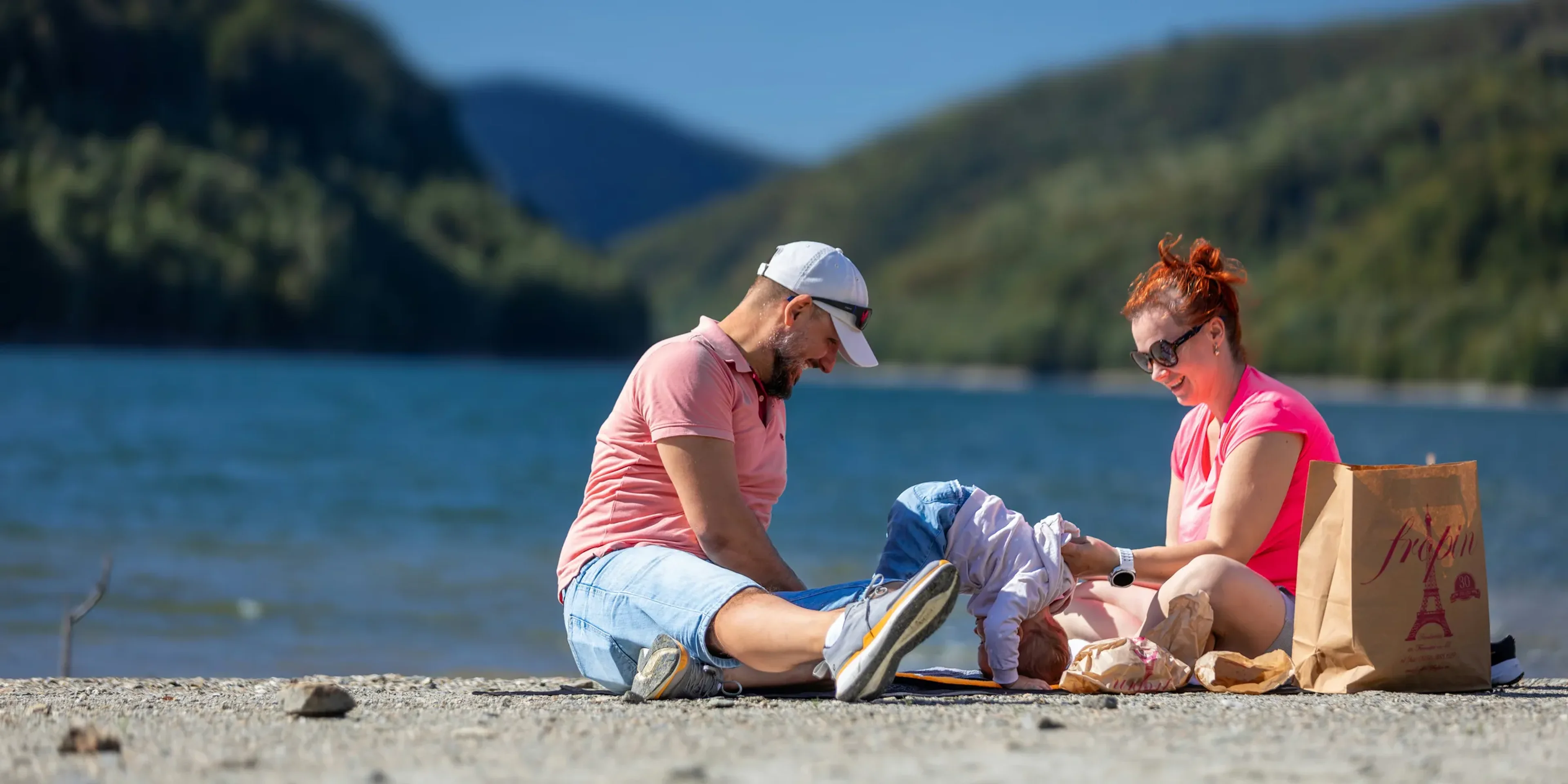 Family relaxing by a lake on a sunny day
