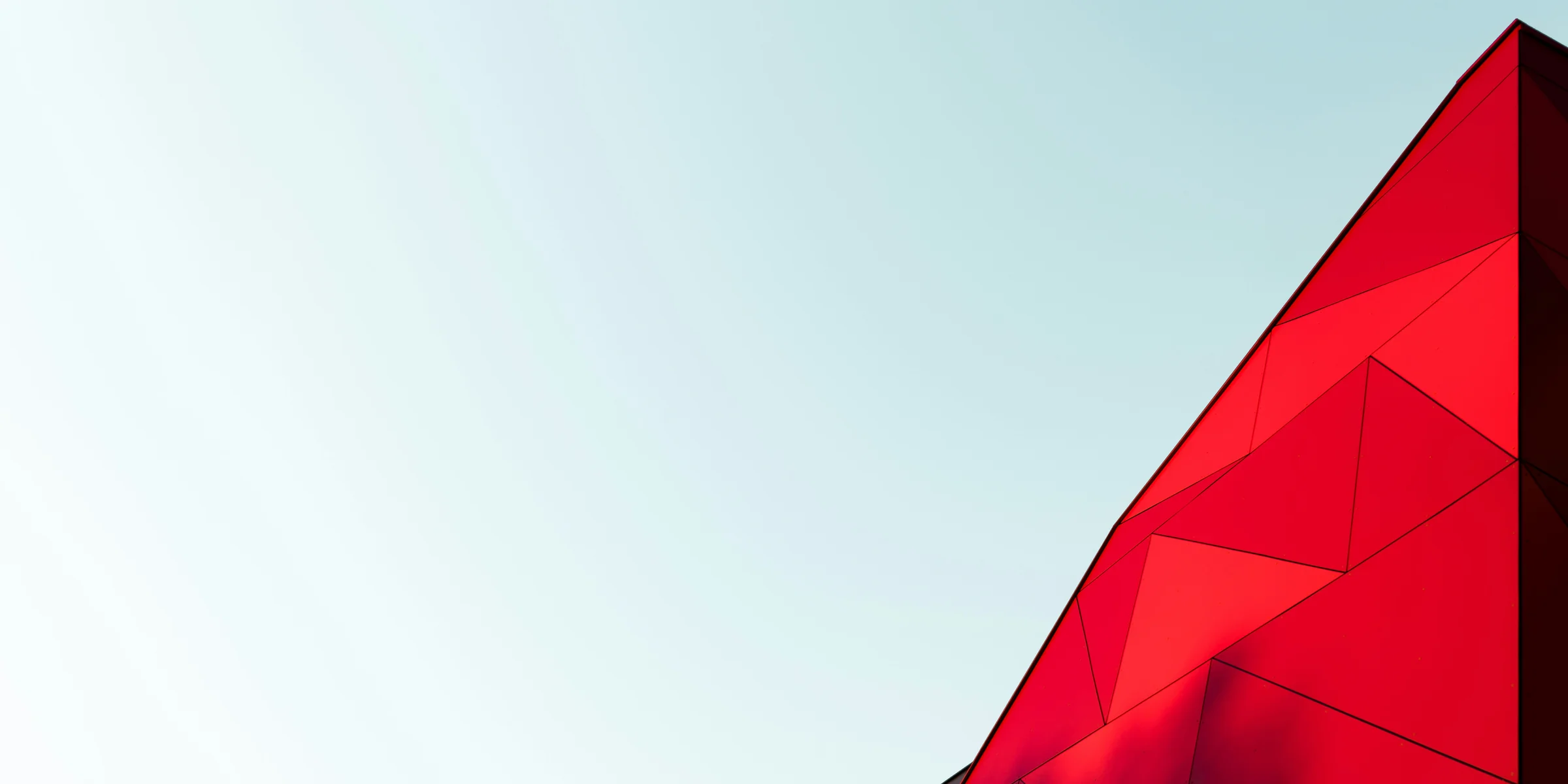 A light blue sky with a bright red, triangular top of a building just visible.