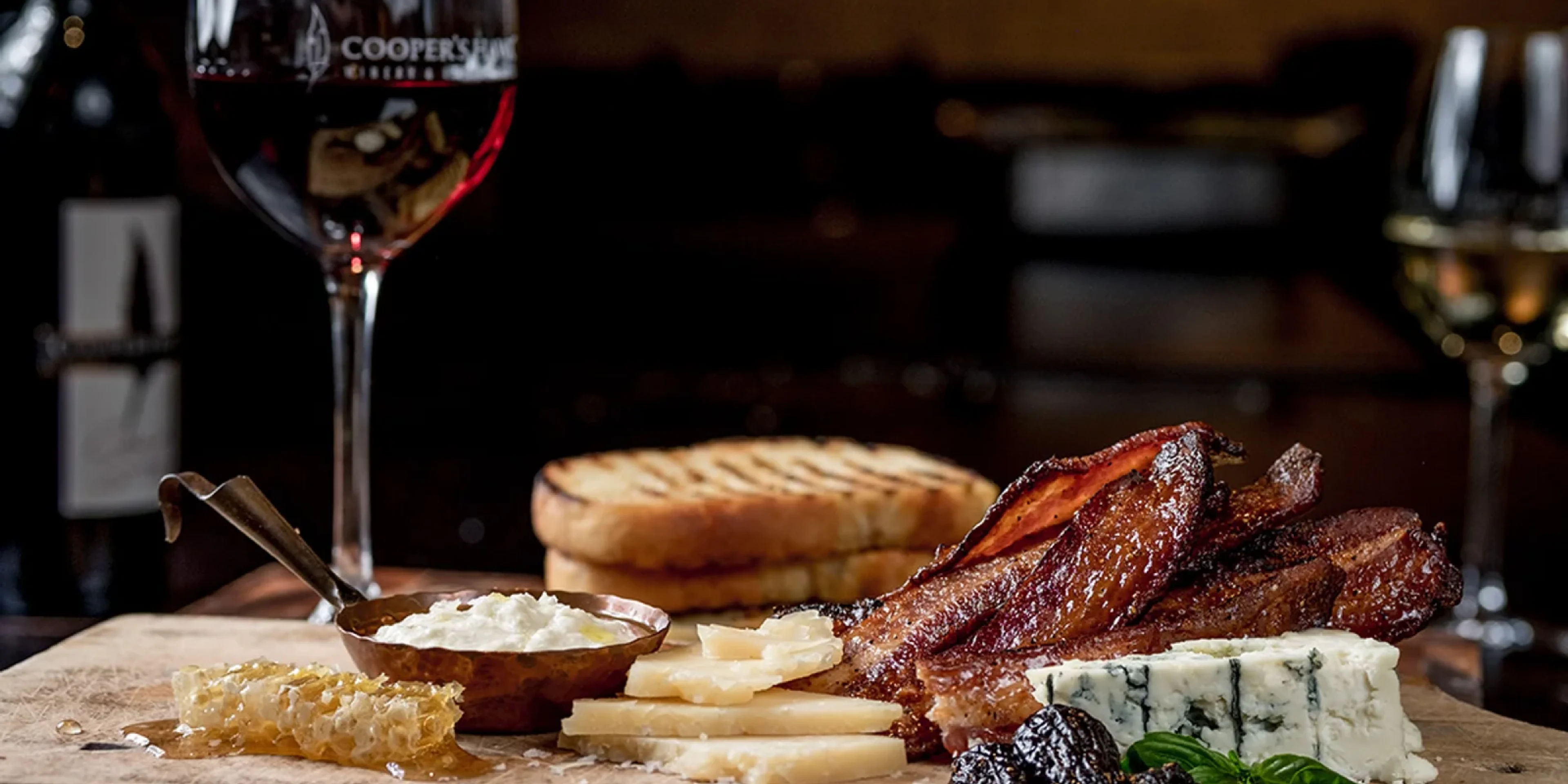 wine glass and charcuterie board, dark ambiance