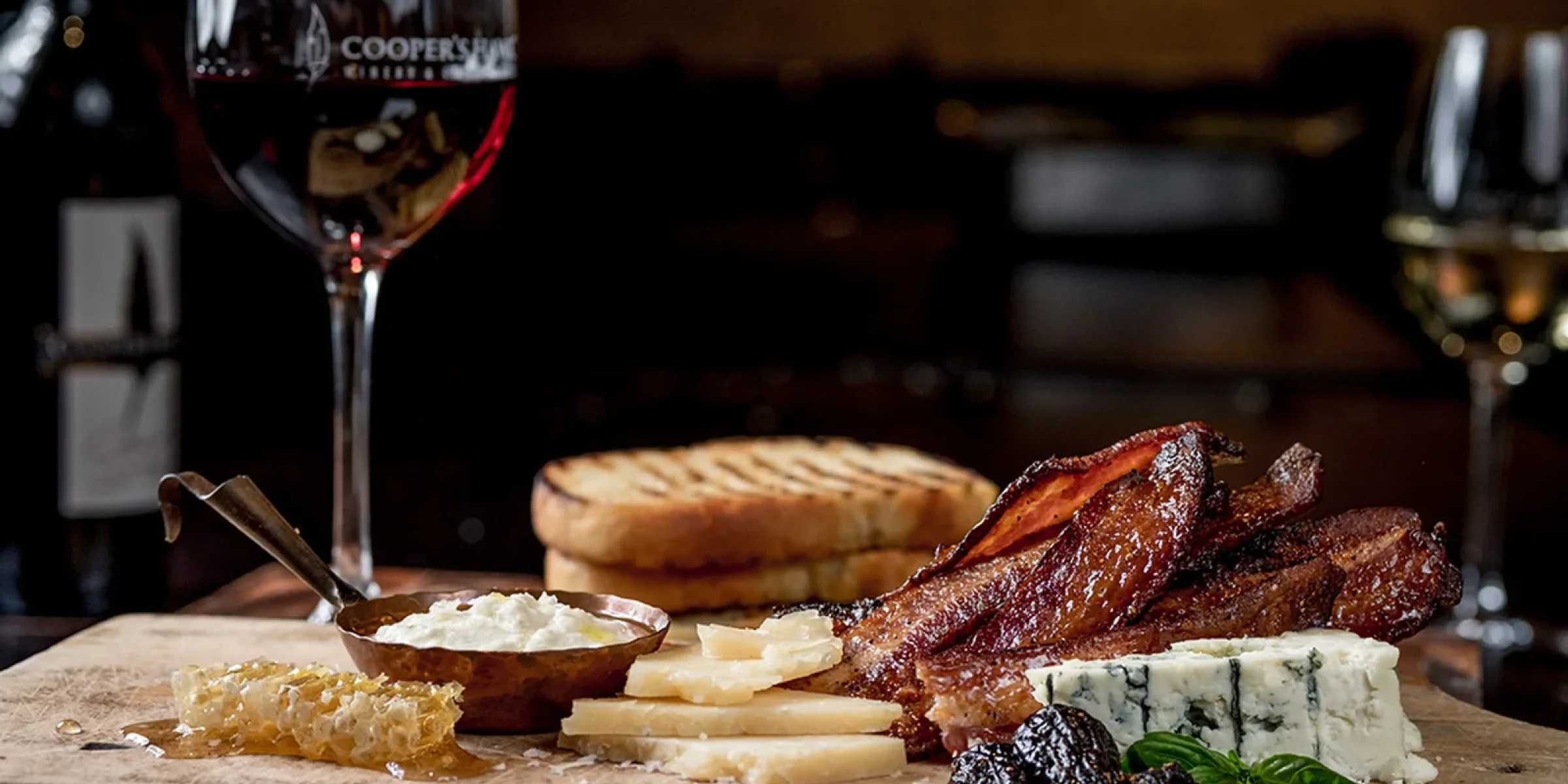 wine glass and charcuterie board, dark ambiance