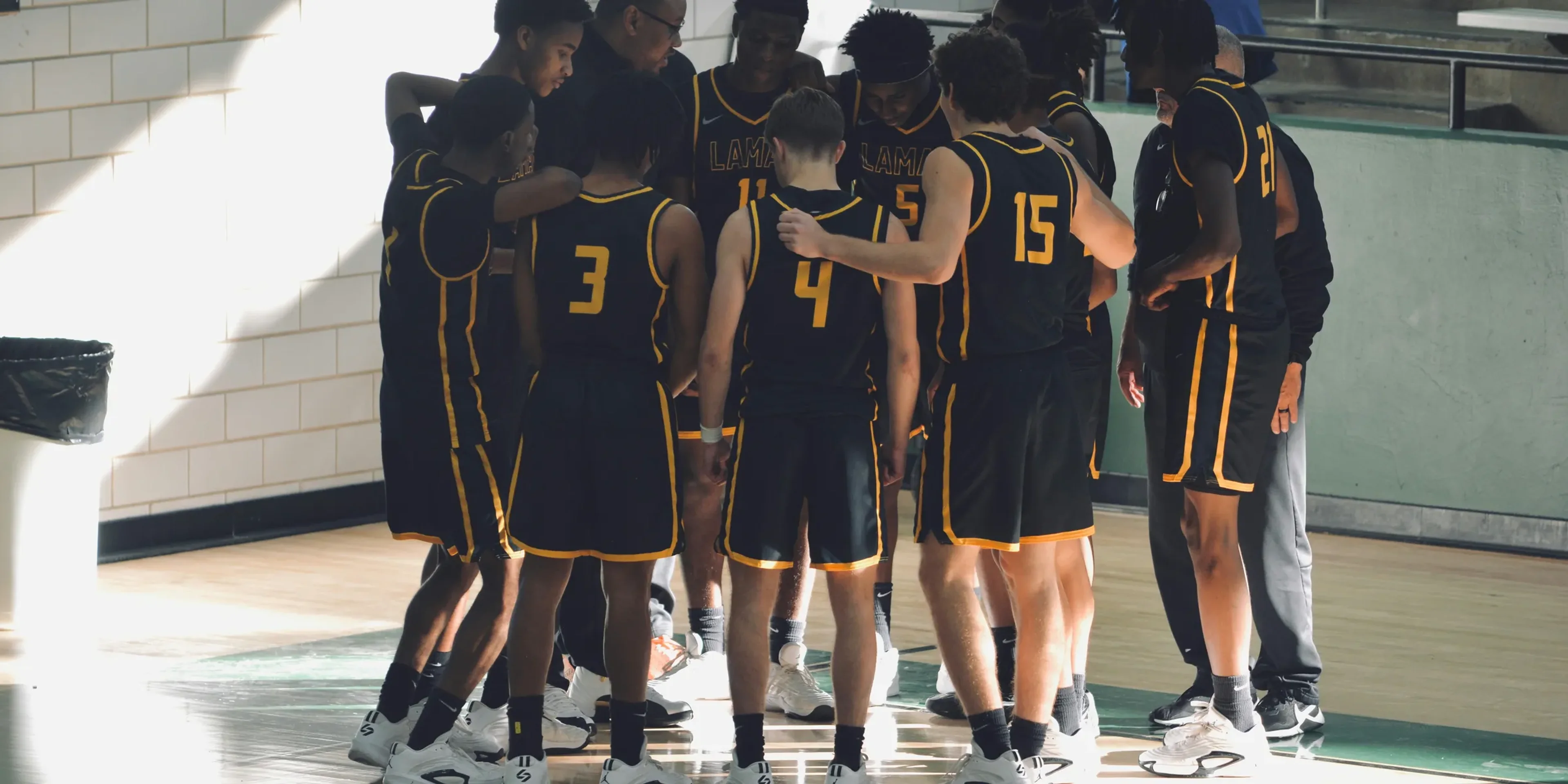 A group of young men standing on top of a basketball court