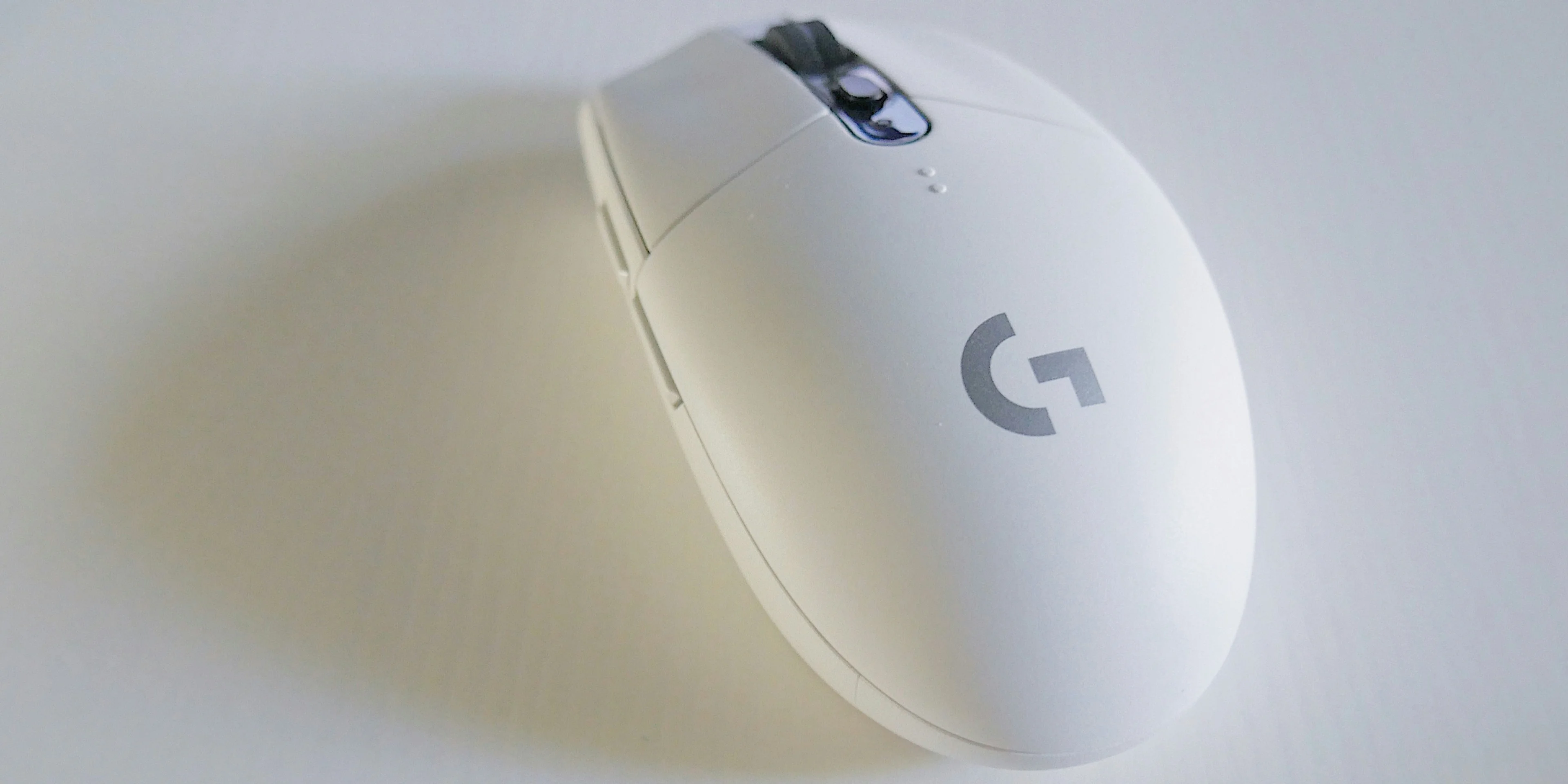 white and grey Logitech G-Series cordless mouse on white surface
