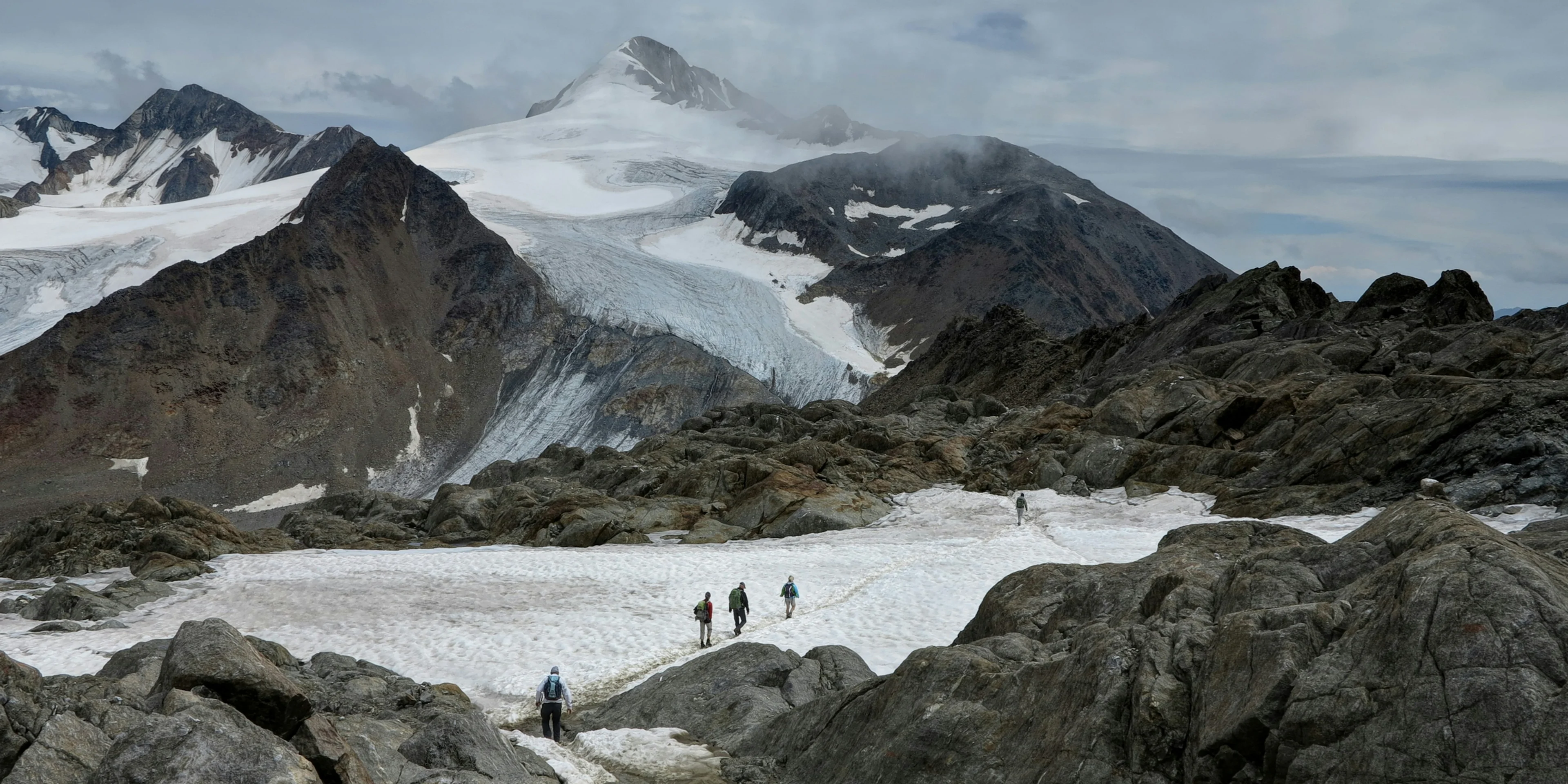 group of people hiking on snowy mountains.
