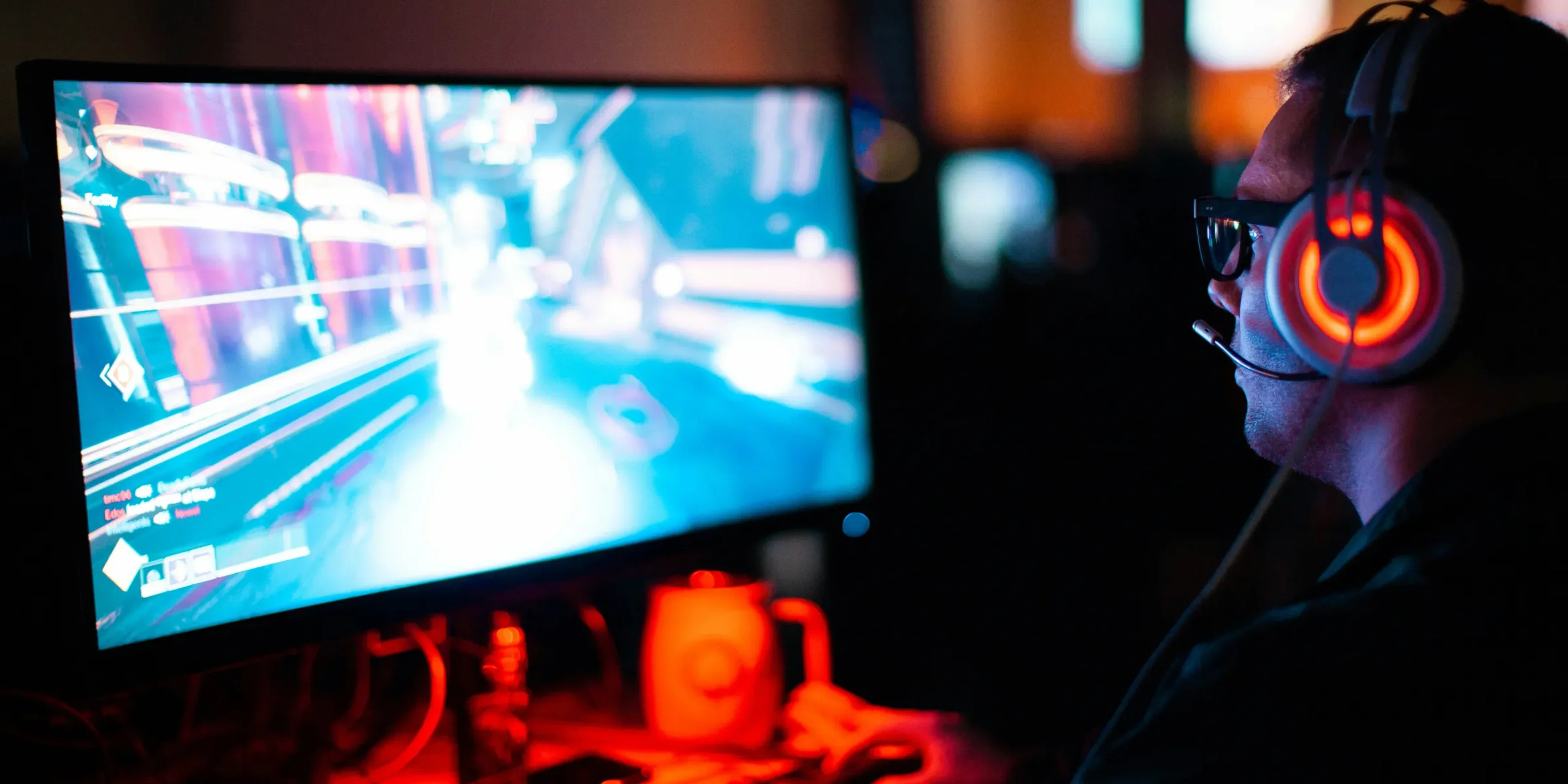 person wearing headphones playing a video game in a dark room