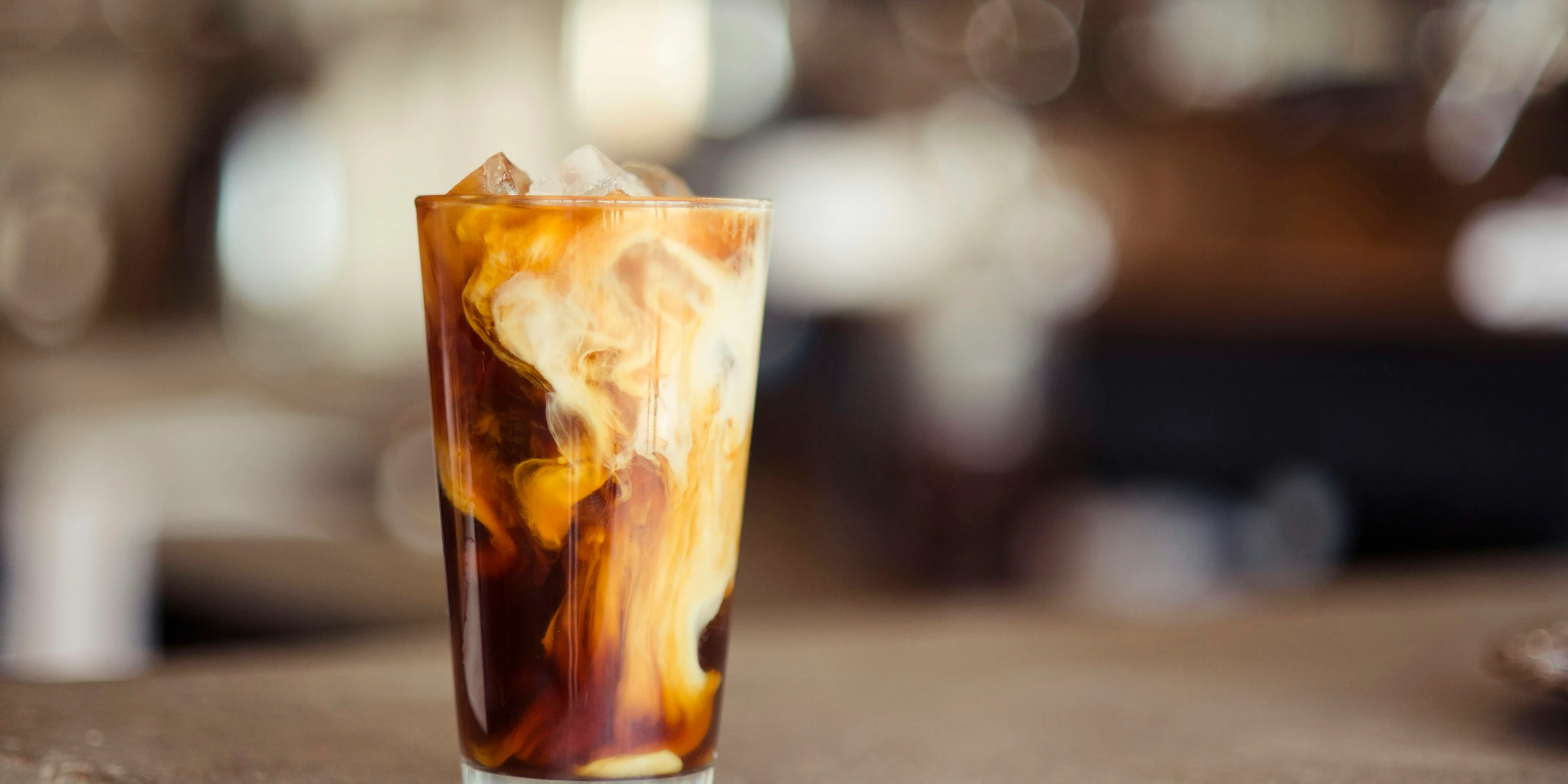 glass cup filled with ice latte on tabletop.