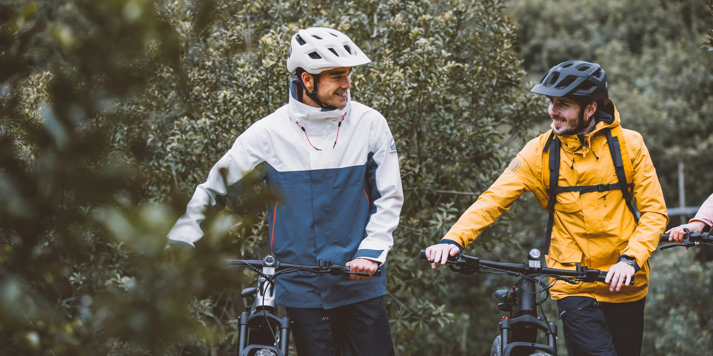 three people standing next to each other with their bikes.