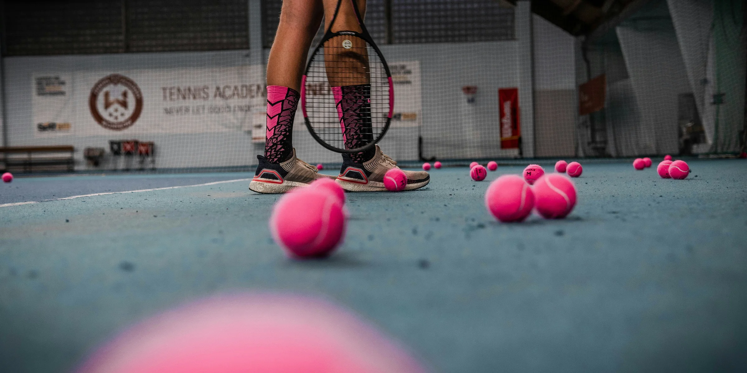 a person standing on a tennis court with a racket