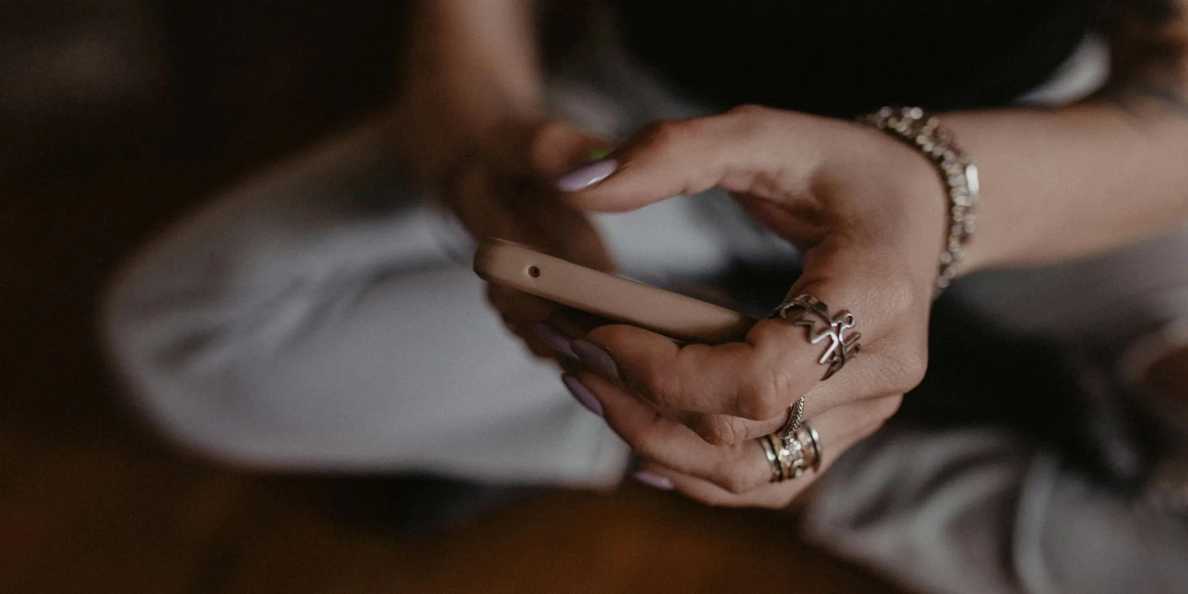 a woman sitting on the floor holding a cell phone