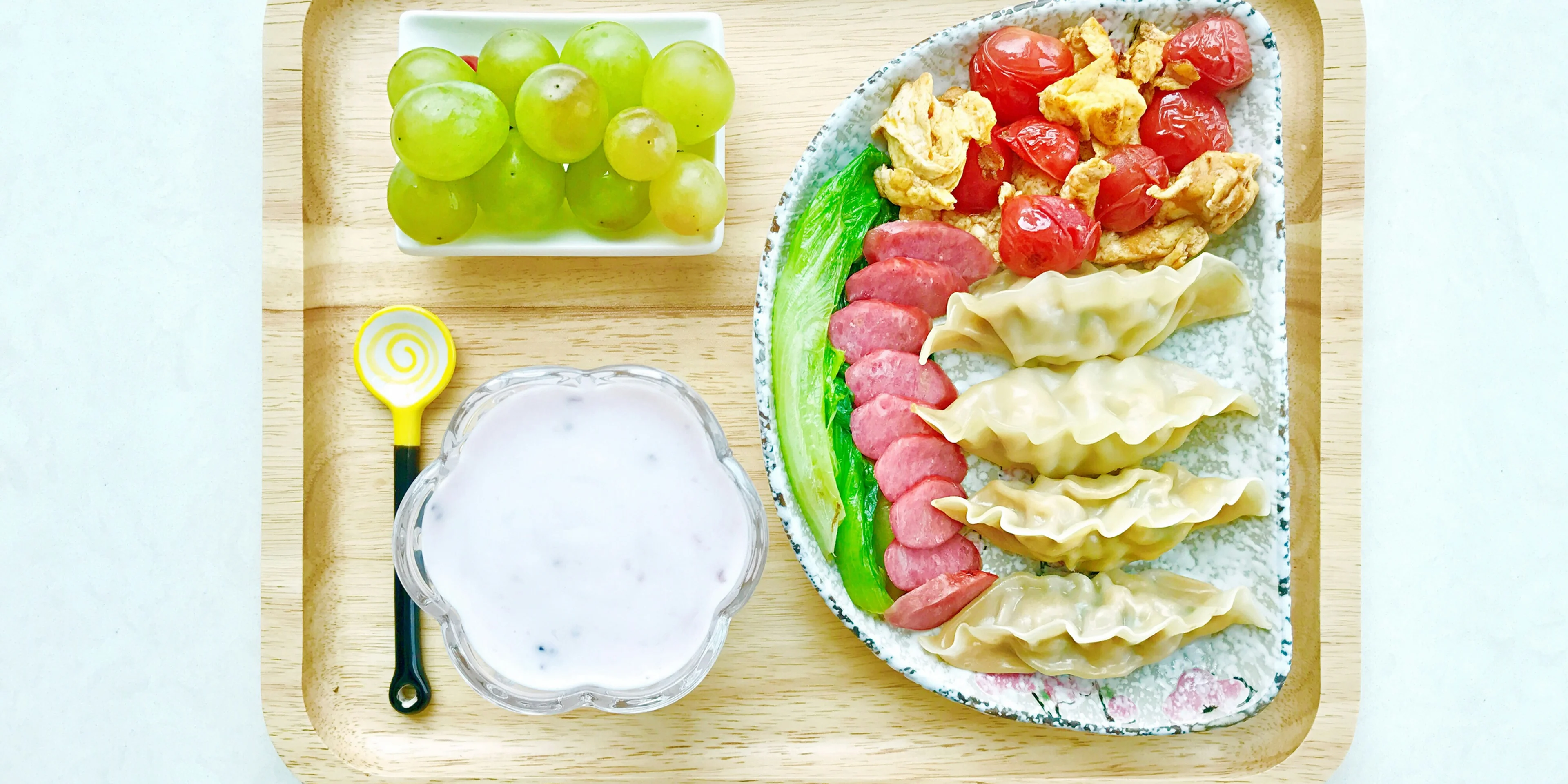 food on ceramic plates on square wooden tray.