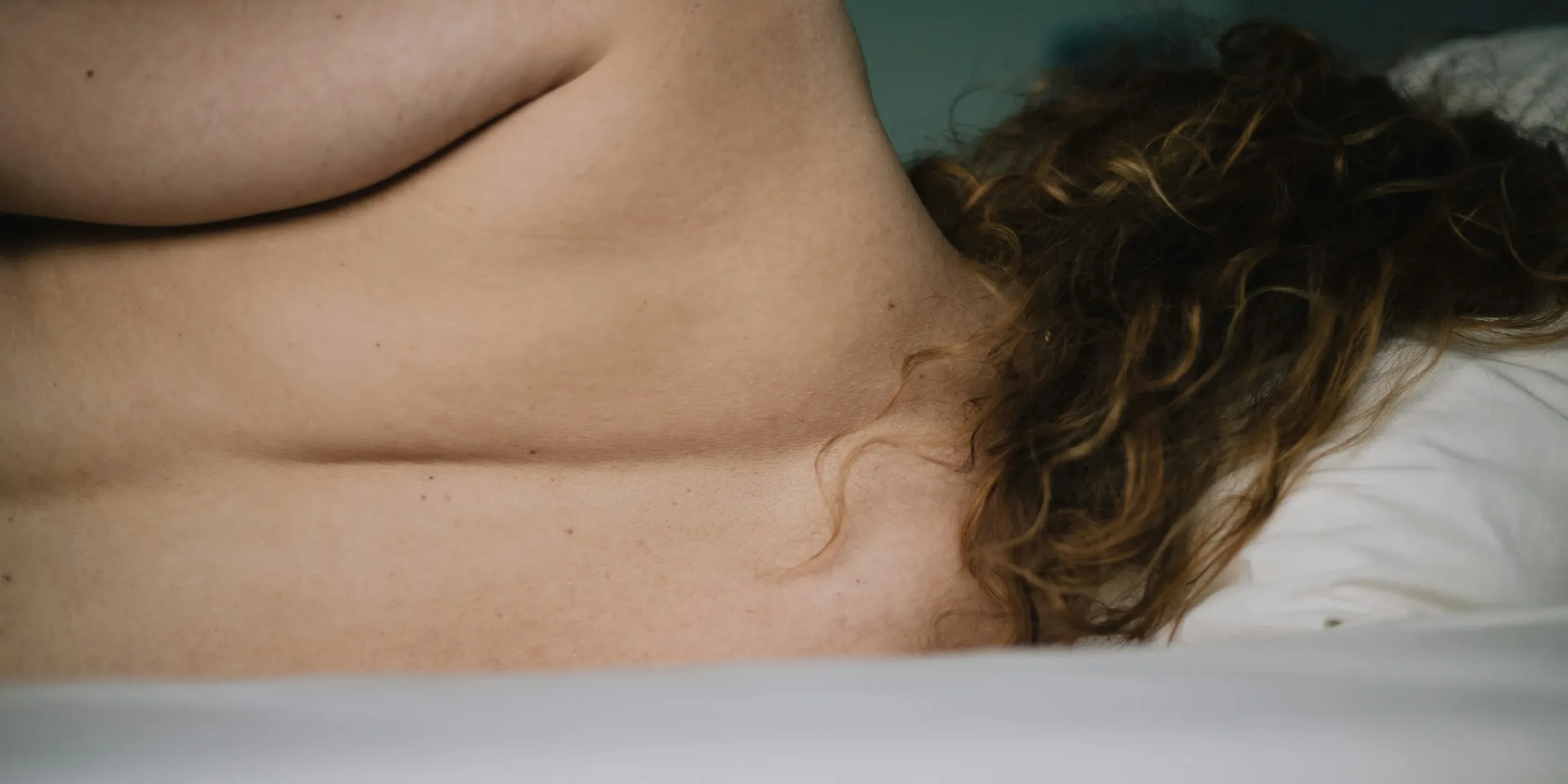 topless woman lying on white bathtub