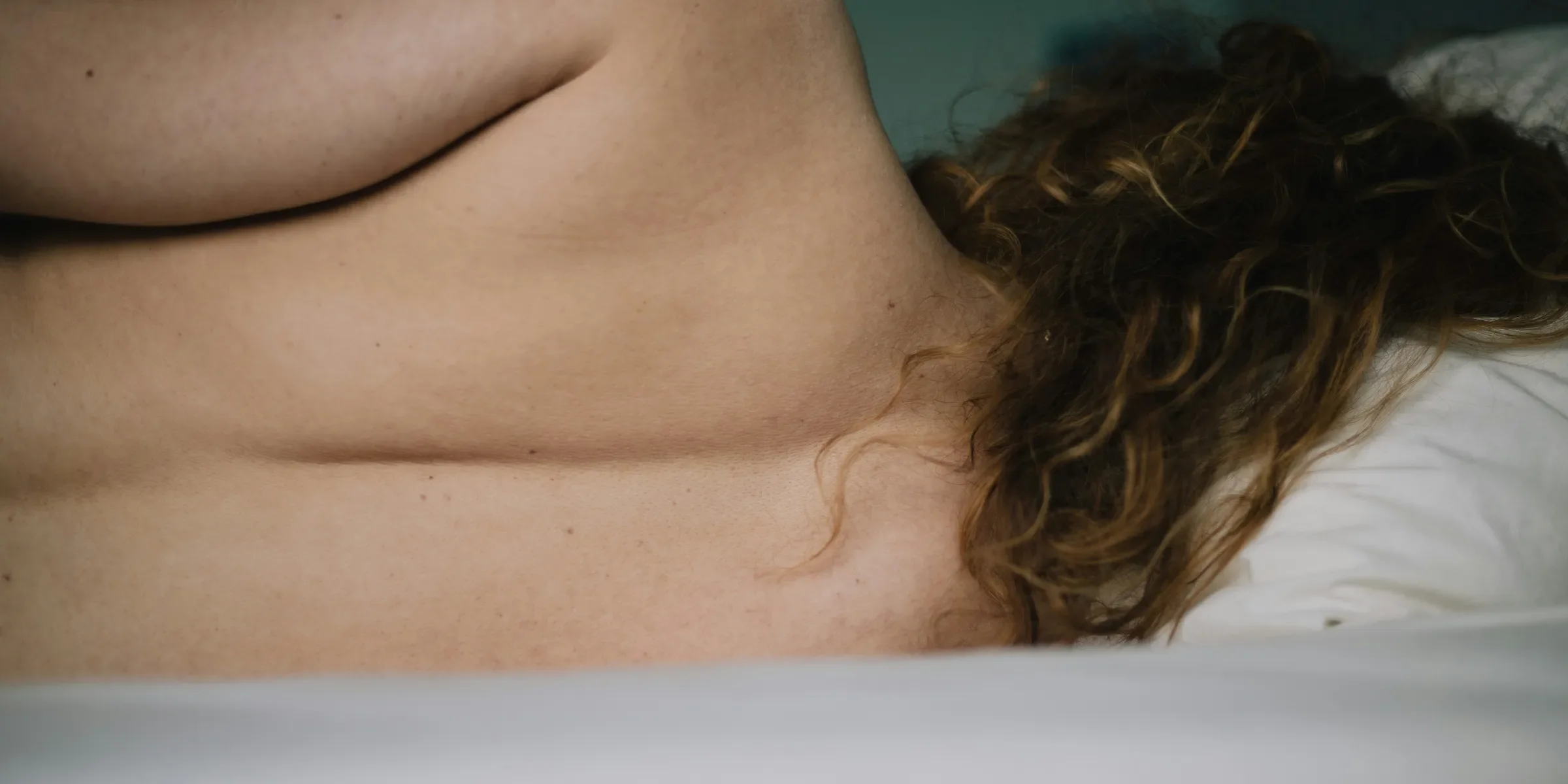 topless woman lying on white bathtub