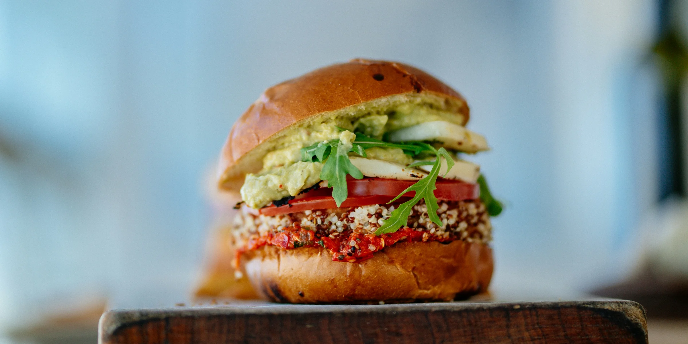 selective focus photography of hamburger with sliced tomatoes and vegetables.