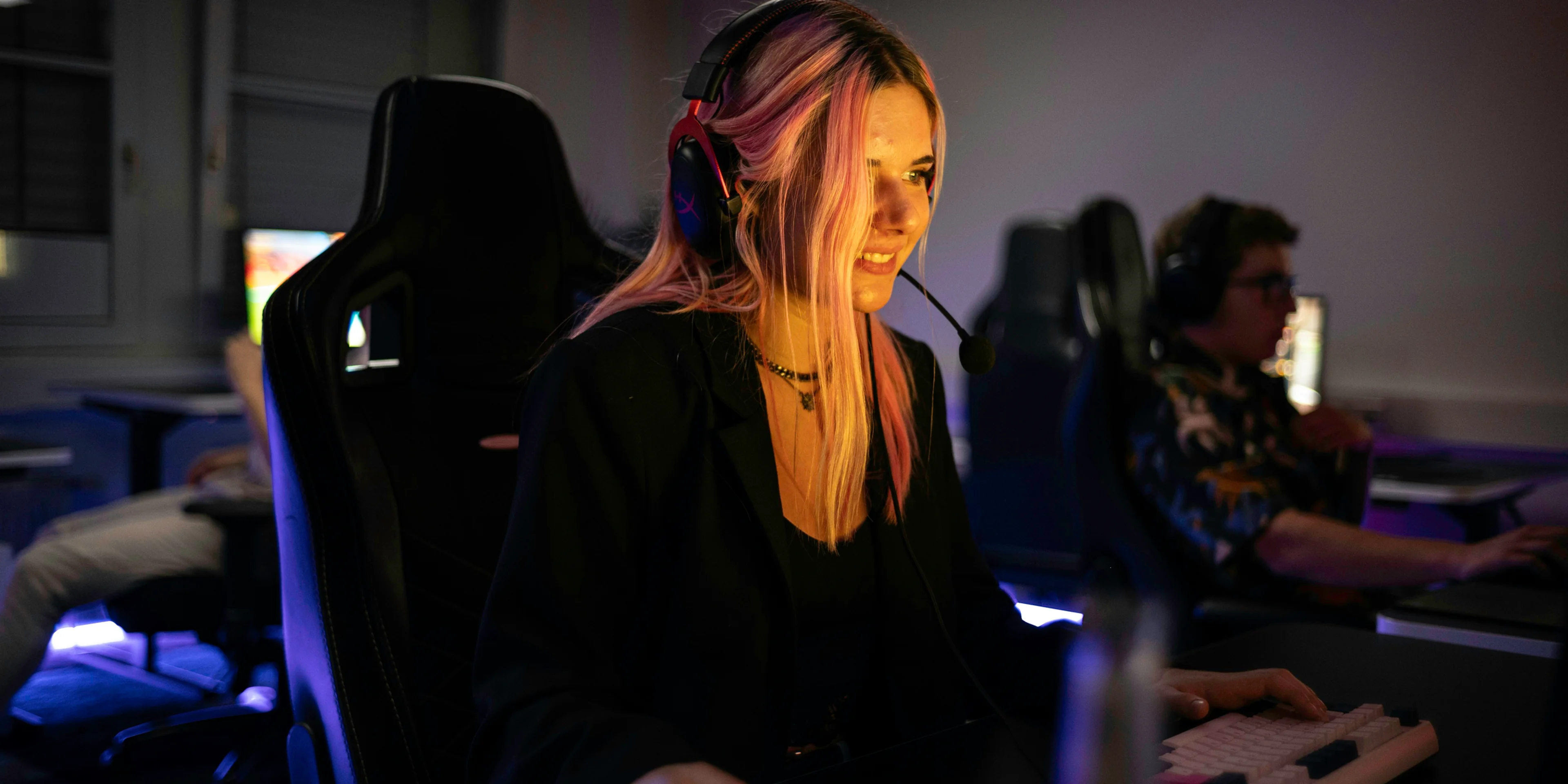 A woman sitting at a desk with headphones on.