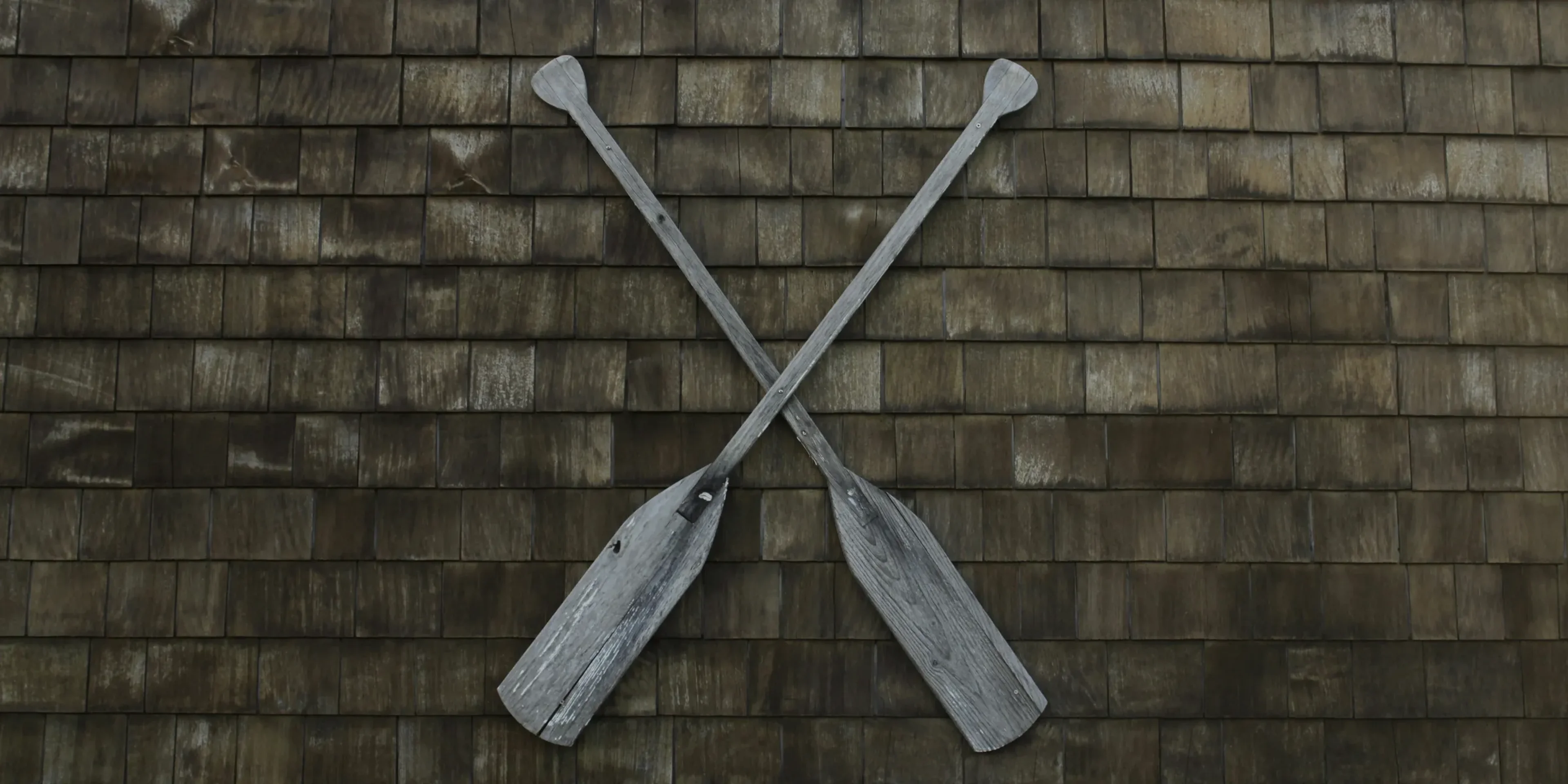 two gray wooden boat paddles hanged on wall
