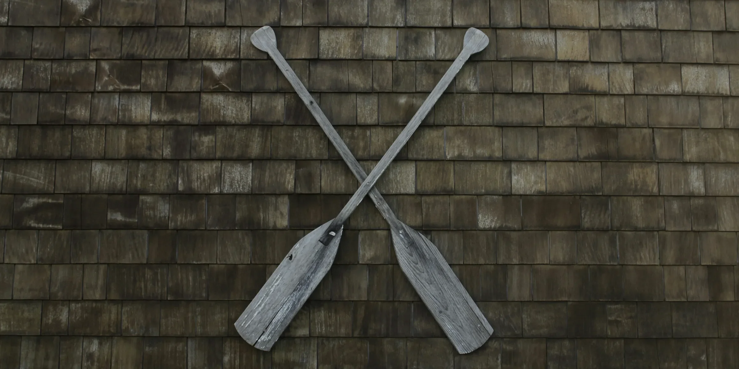 two gray wooden boat paddles hanged on wall