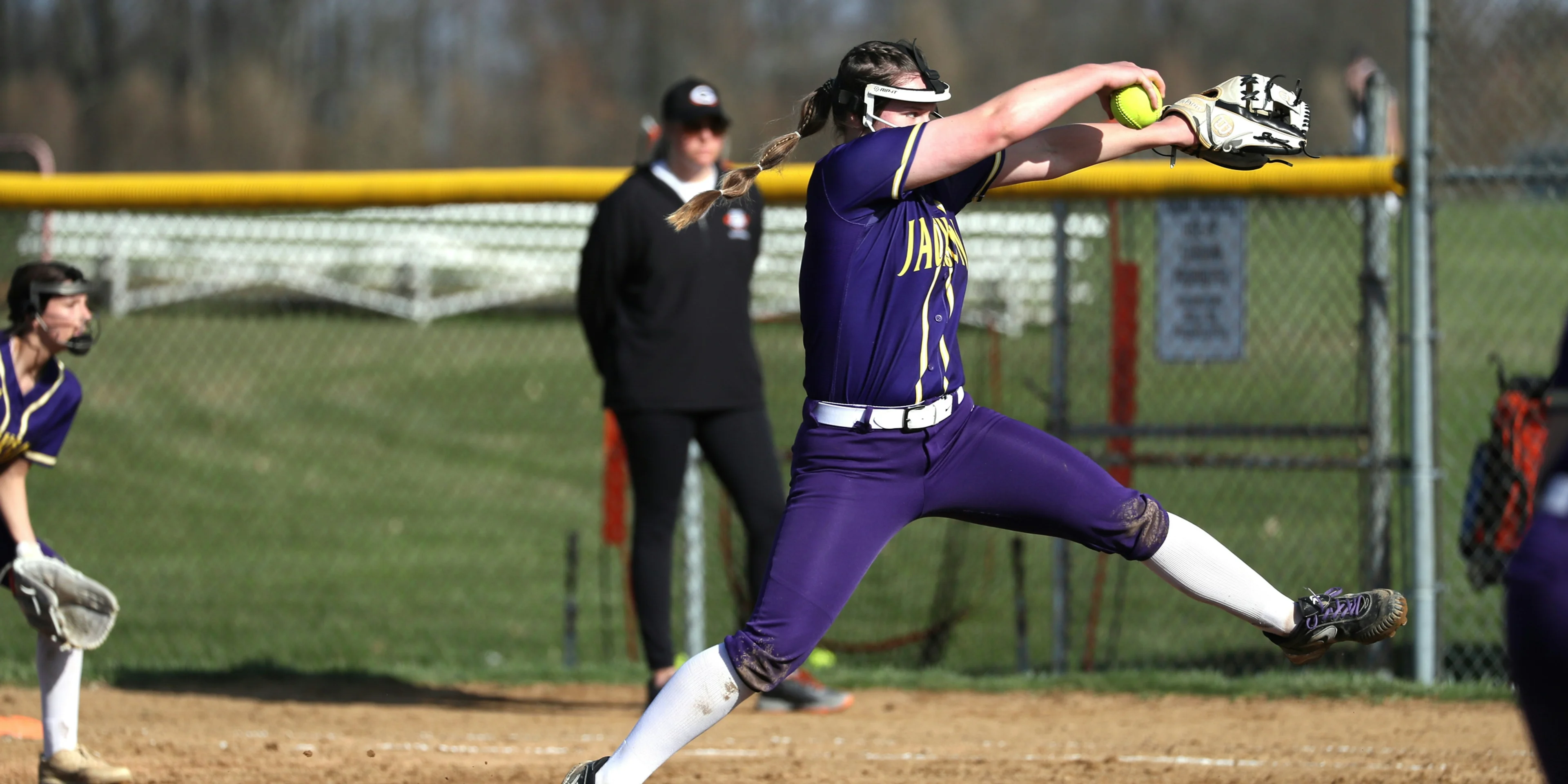 a softball player throwing a ball on a field