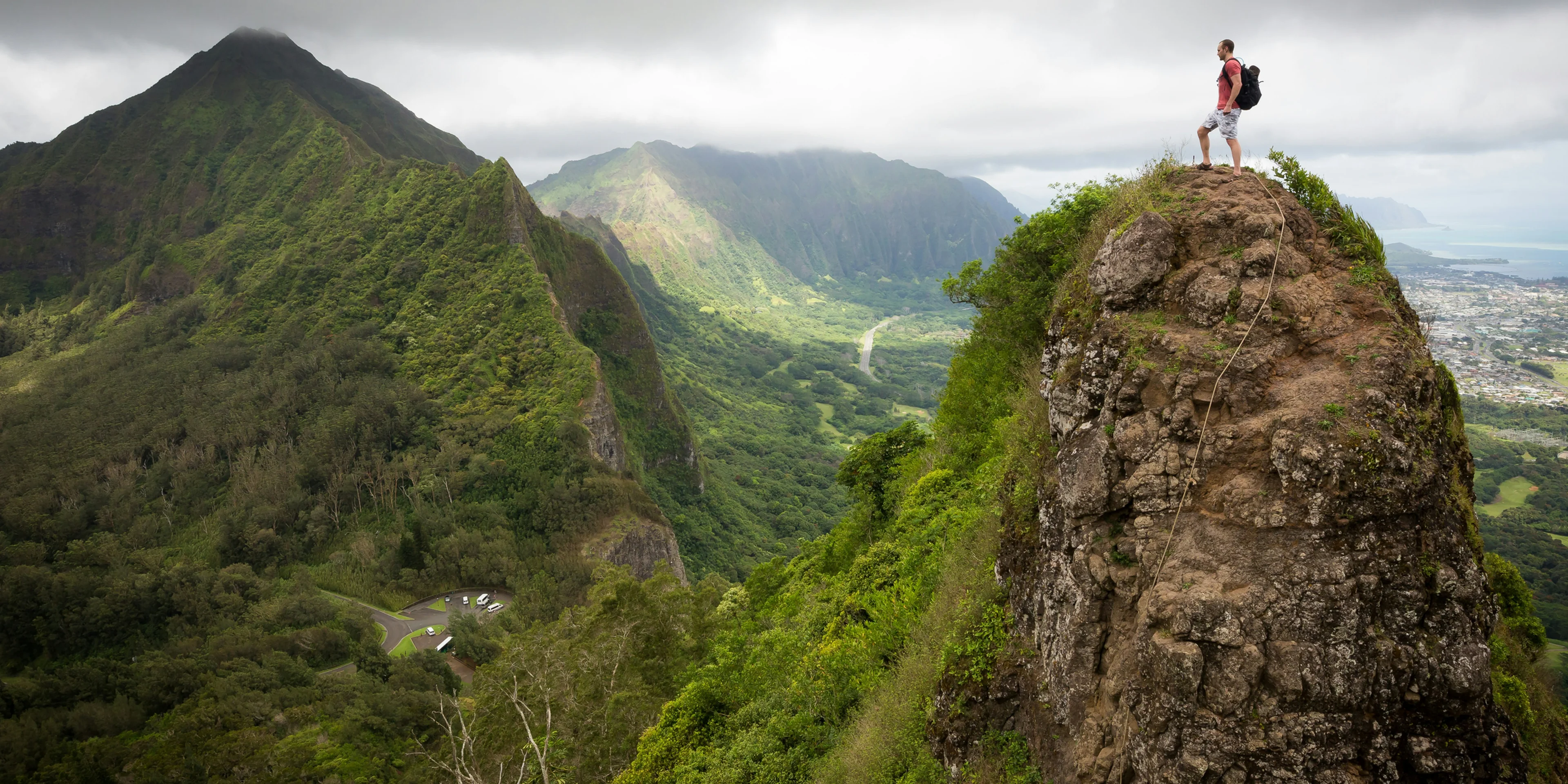 man on top of the mountain during daytime.