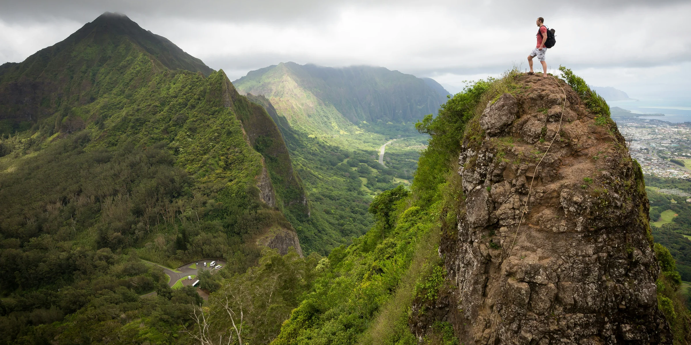 man on top of the mountain during daytime.