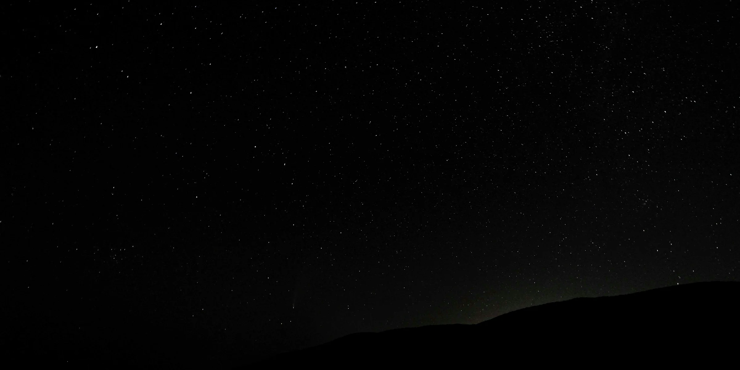 silhouette of mountain under starry night