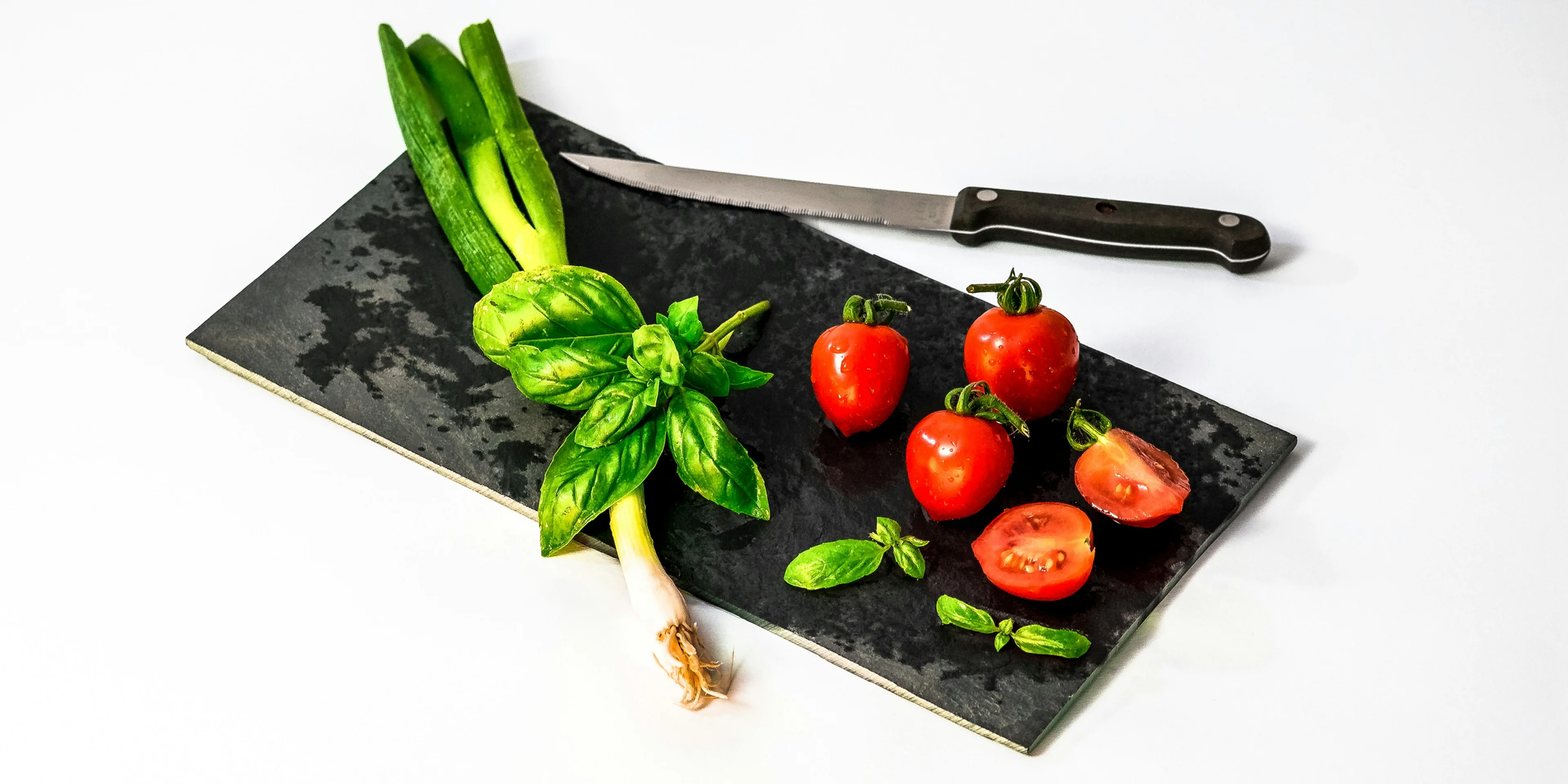 slice of tomato on board beside knife.