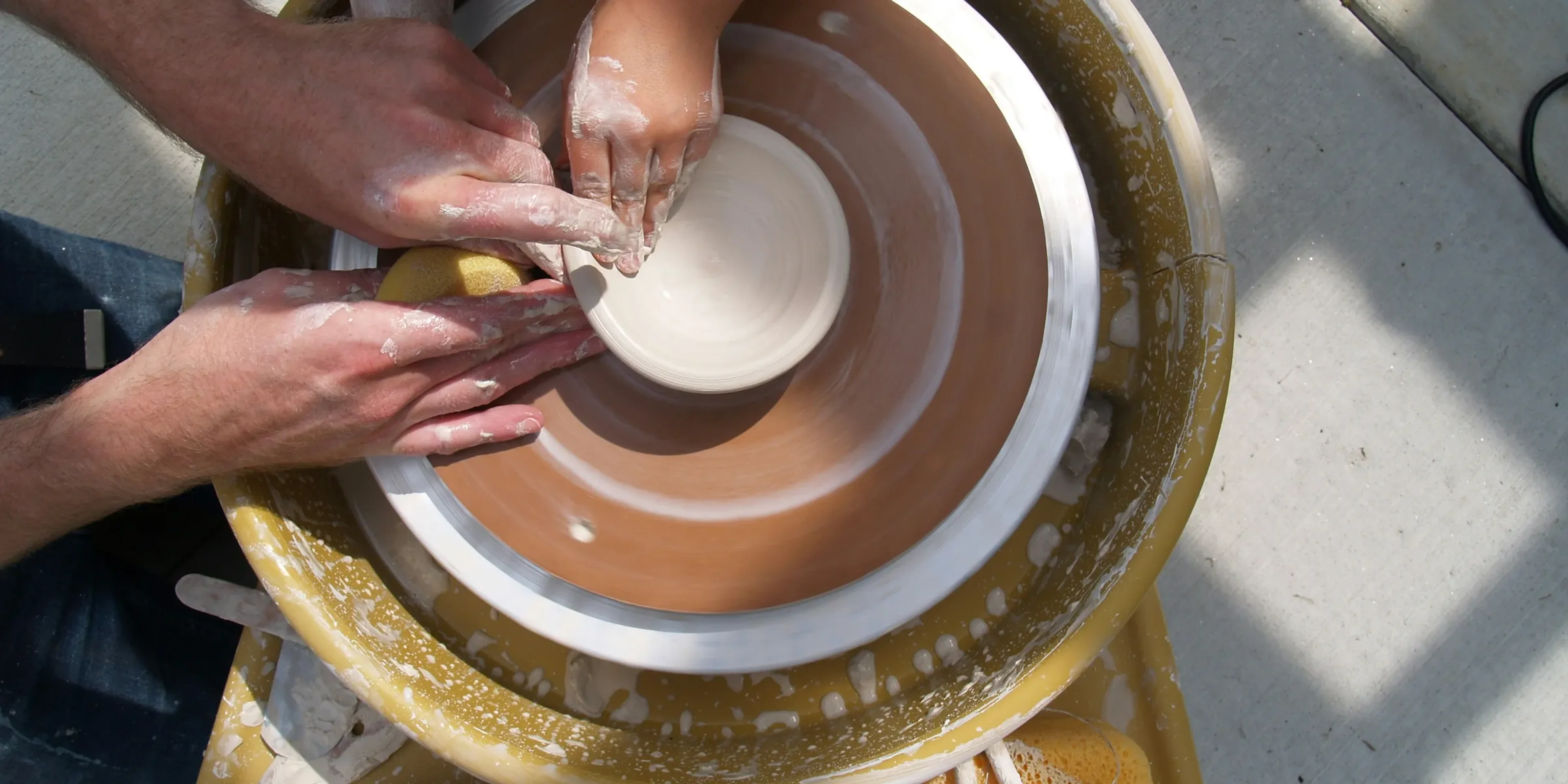 a group of people working on a pottery wheel