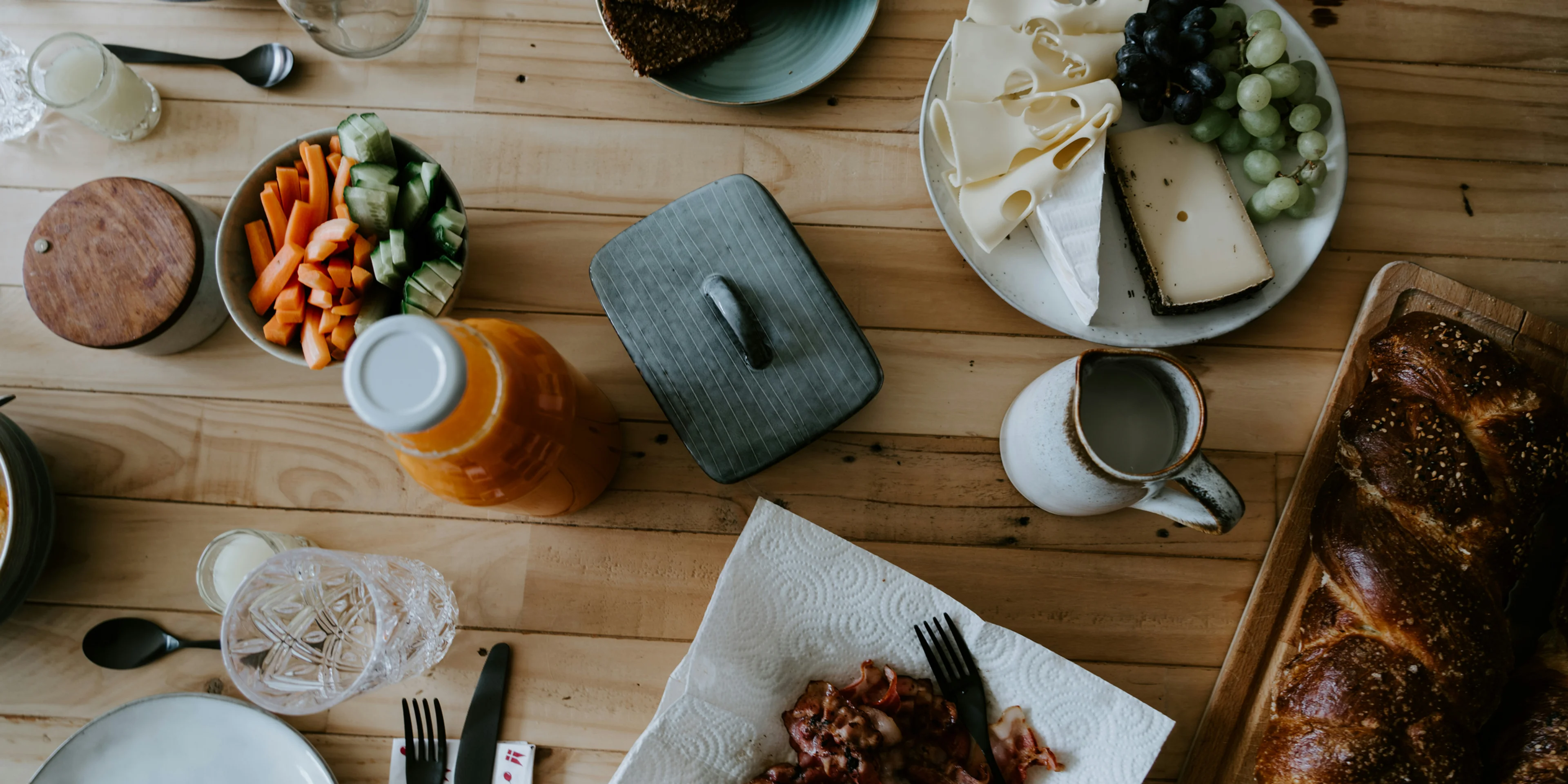 a wooden table topped with plates of food.