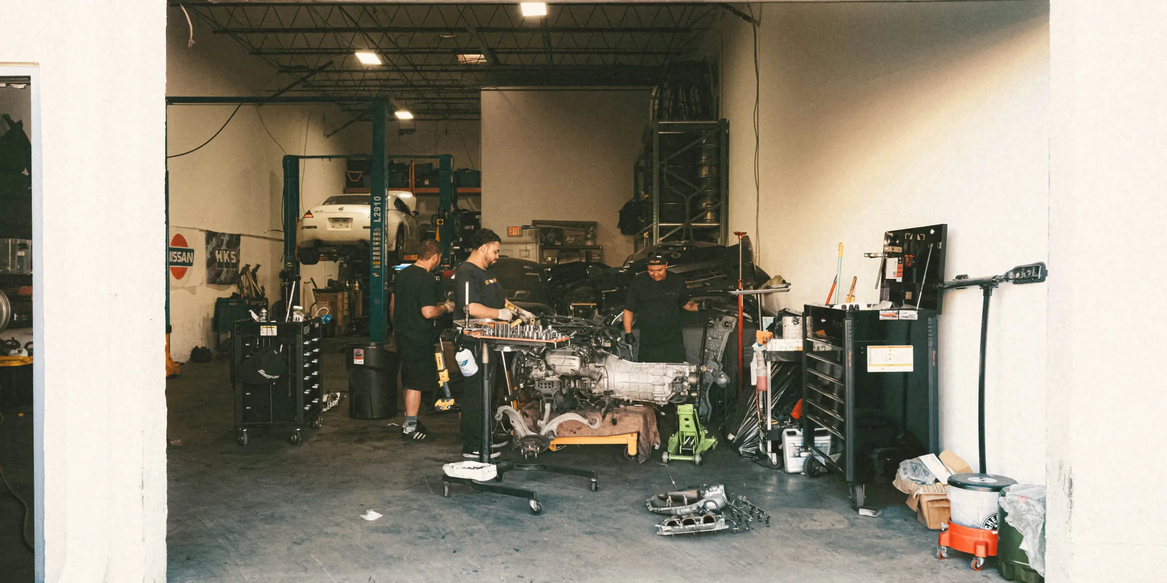 a group of men standing in a garage next to each other