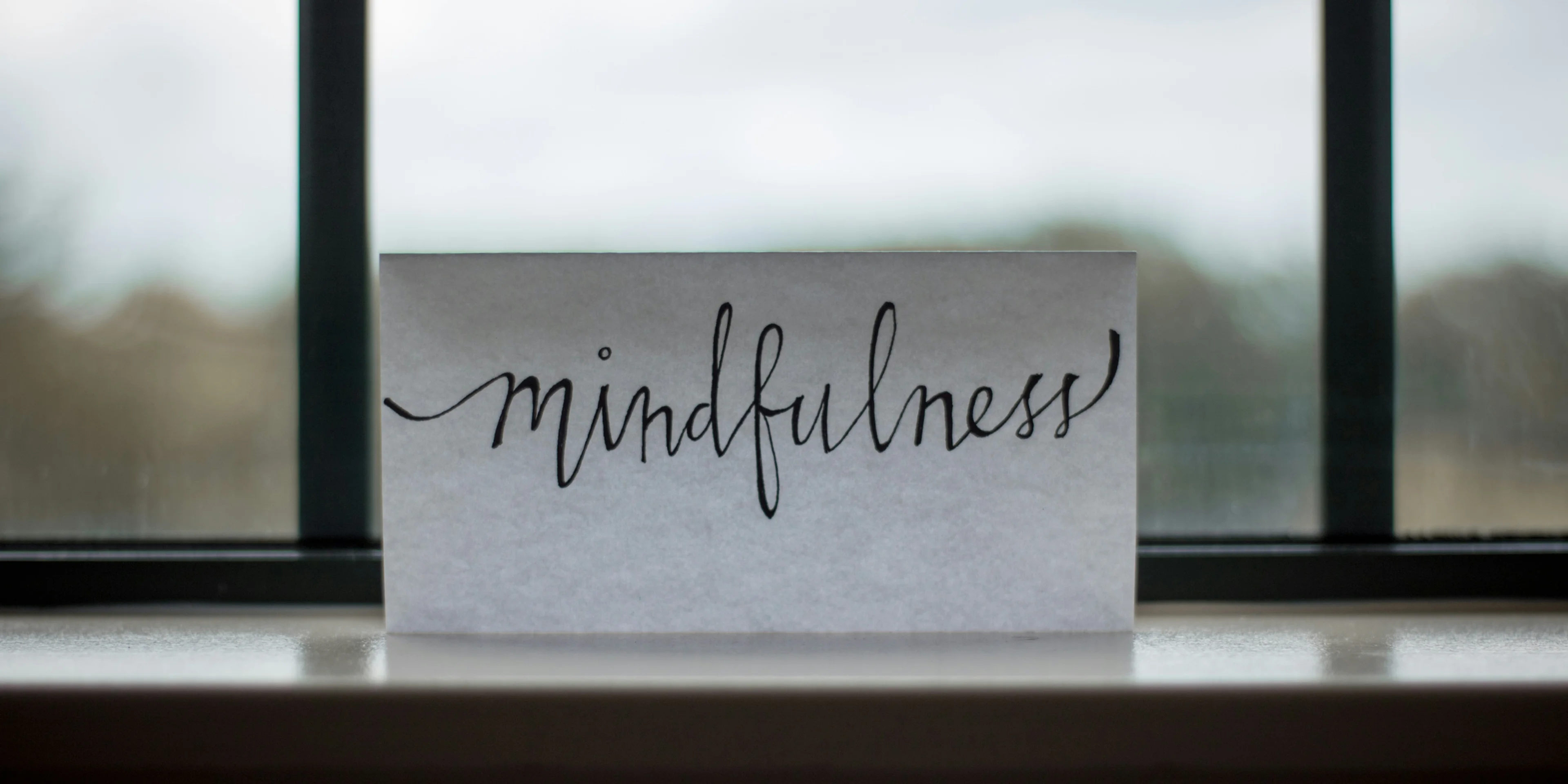 mindfulness printed paper near window.
